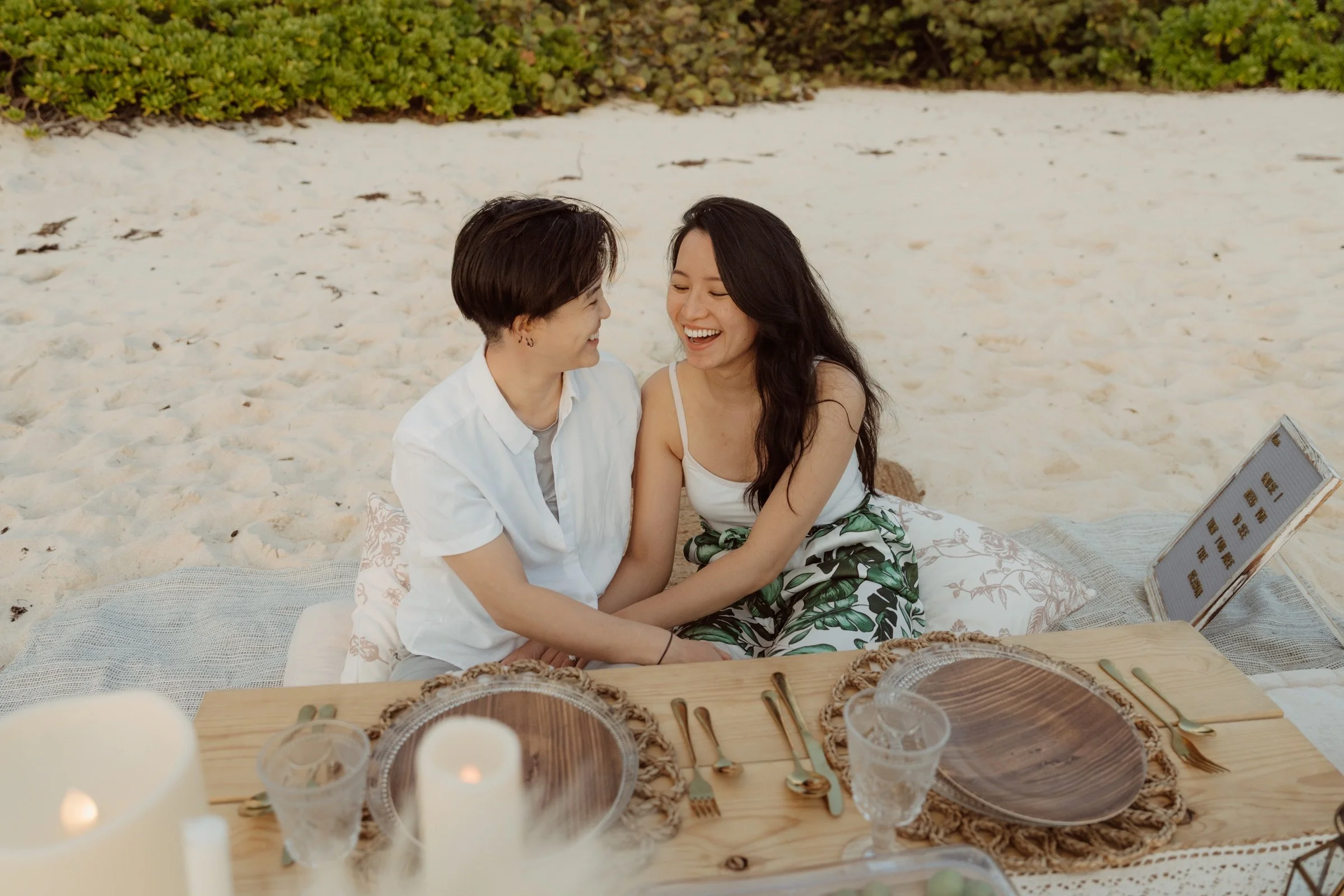 Guests laughing together at a Soirées beach picnic in Grand Cayman