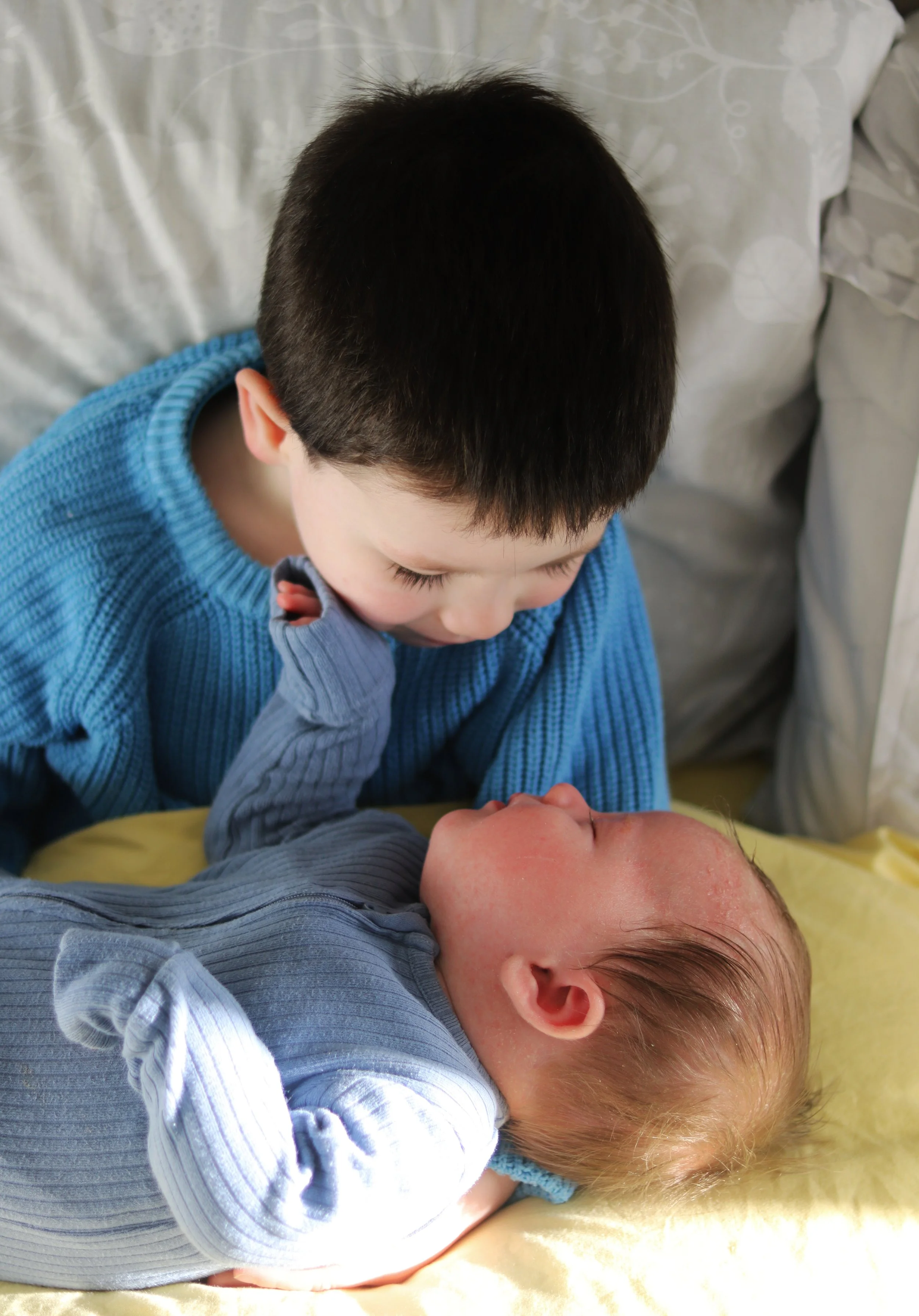 Older sibling and baby brother during at-home newborn photography session