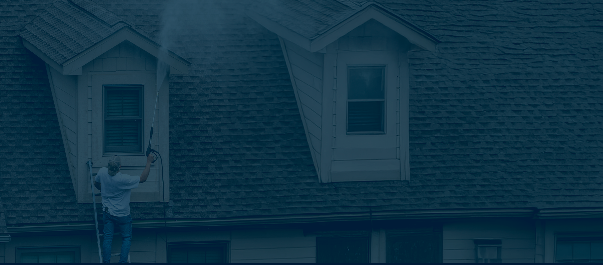 A person cleaning or inspecting the exterior of a house's window on a rooftop with a long pole.