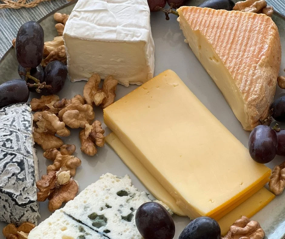 Branzeturi asezate pe un platou cu nuci si struguri