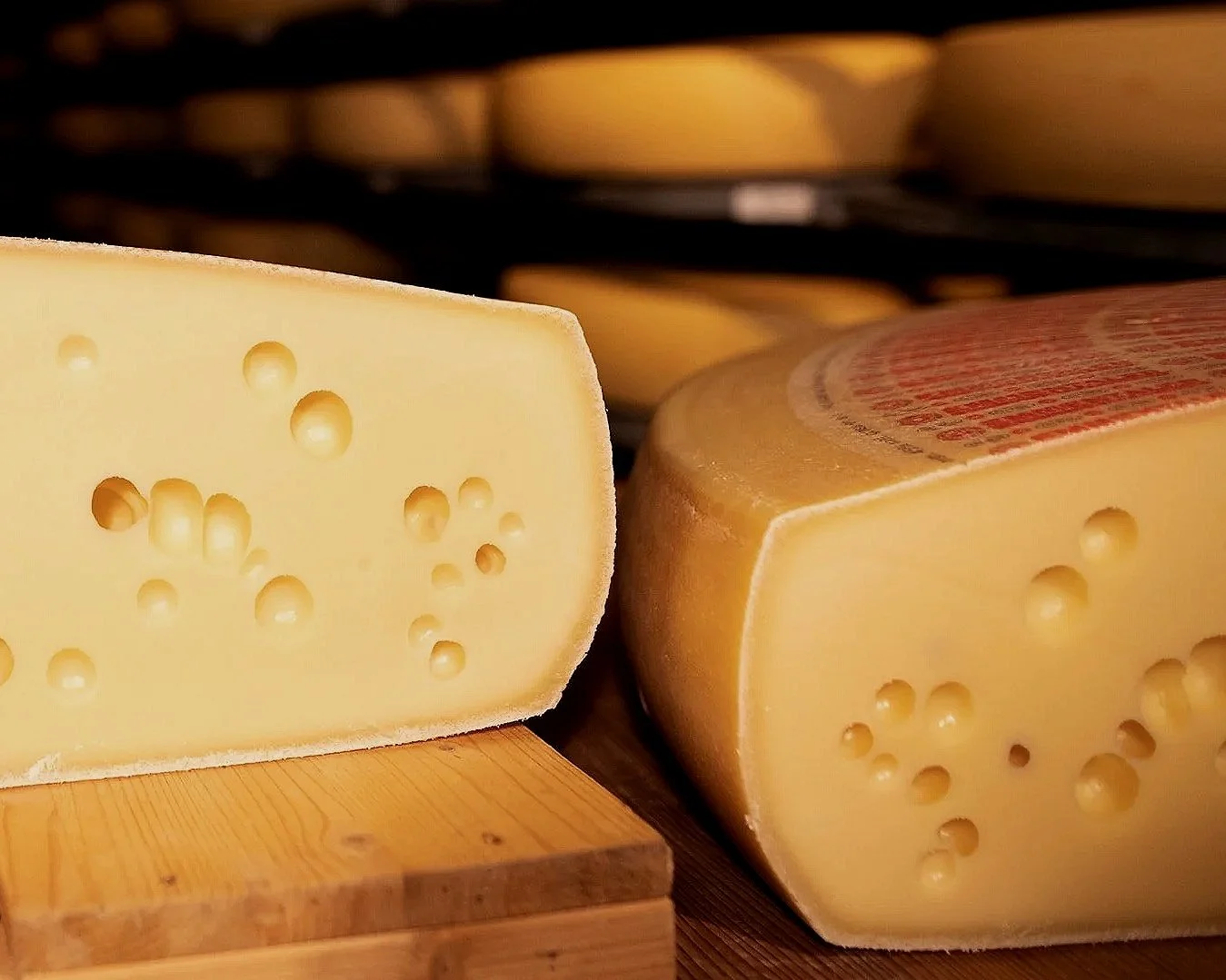 Branza Emmental sectionata pentru expunerea gaurilor, aflata pe un locator de lemn