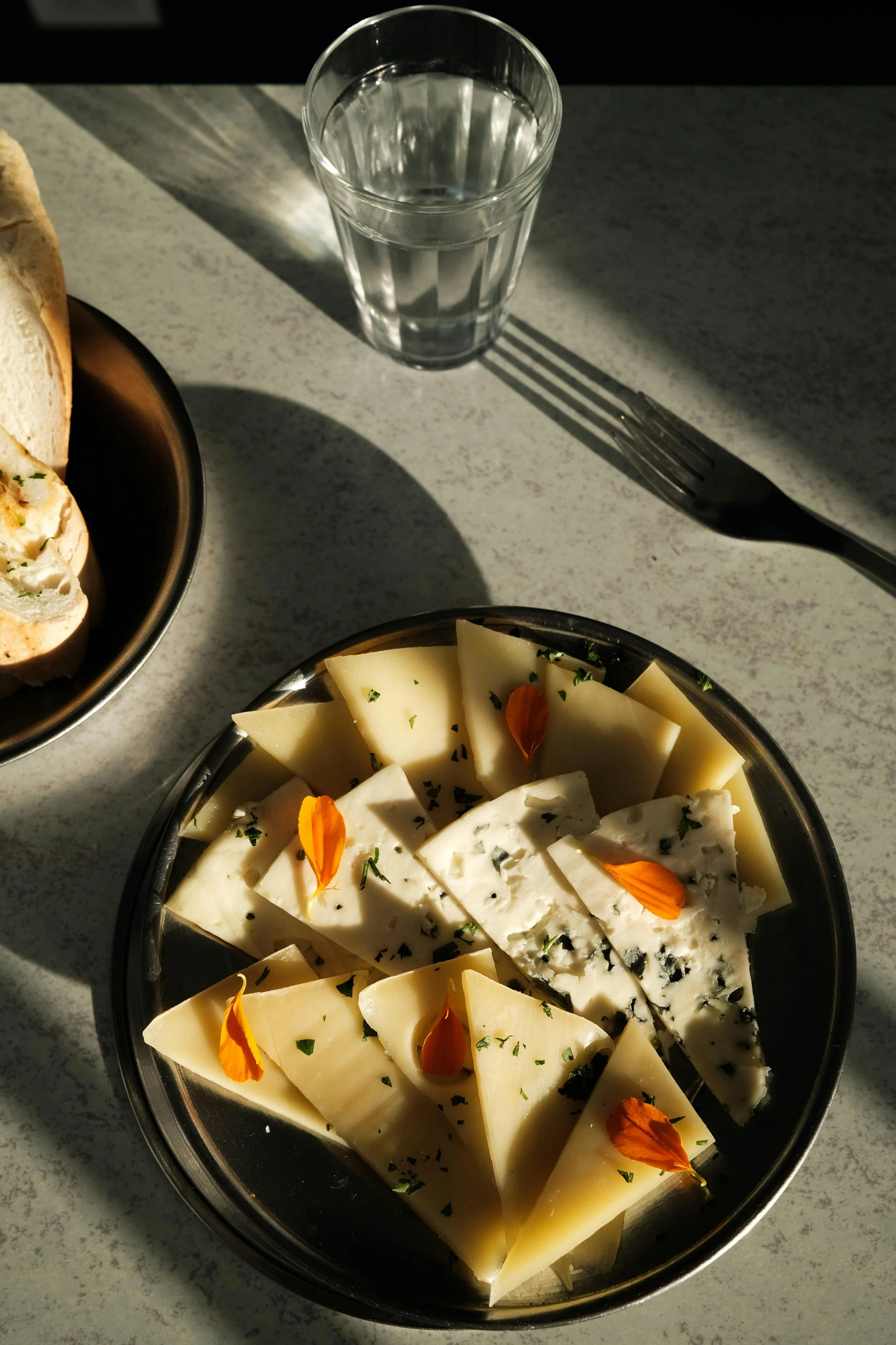 farfurie neagra in Smurf cu trei tipuri de branza si petal de galbenele