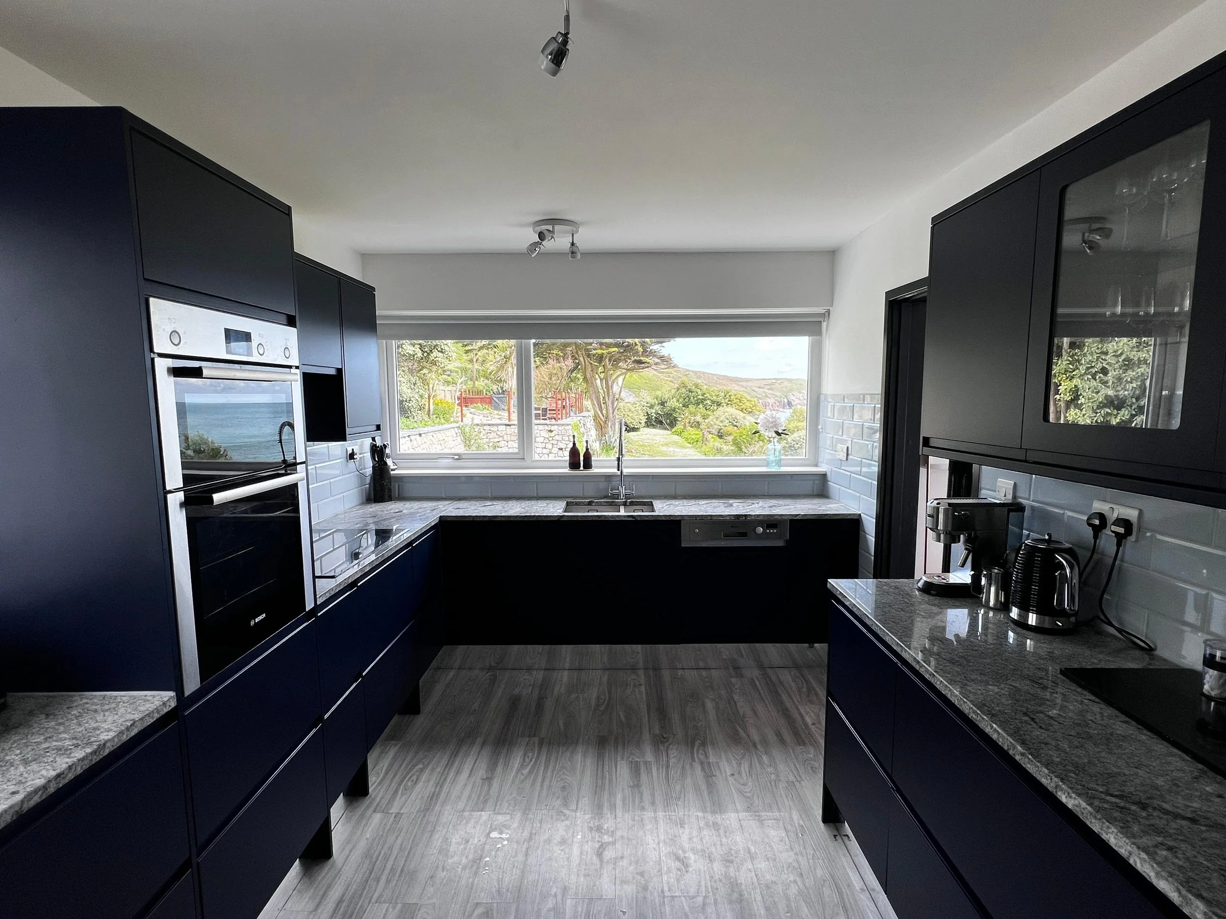 Stylish, fully equipped main kitchen with spacious fridge freezer, wine cooler, range oven, and sea views