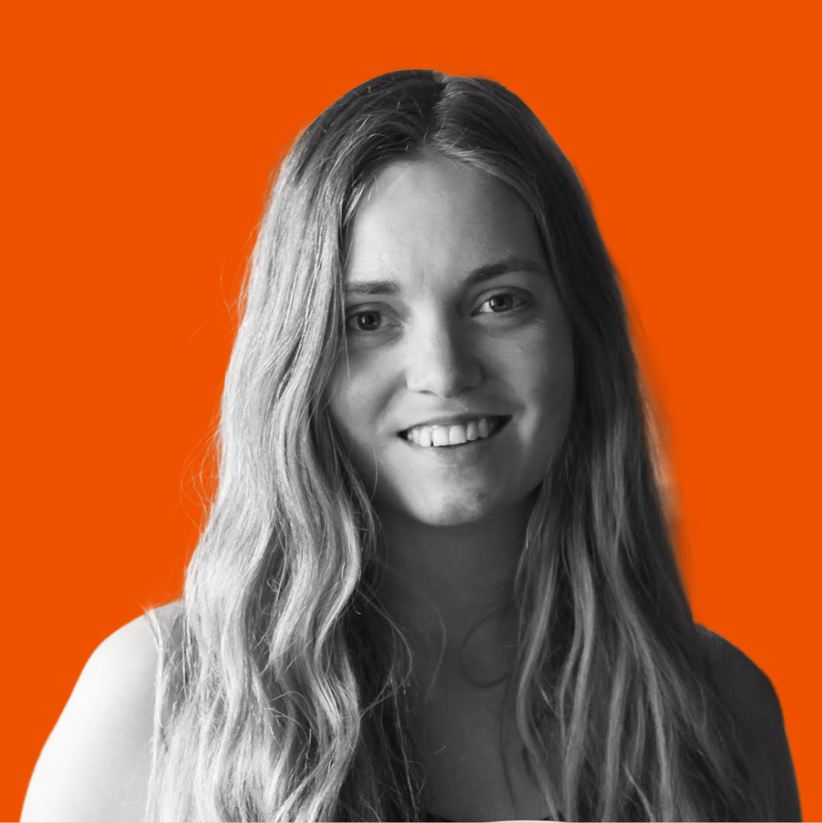 Black and white photo of a smiling woman with long wavy hair against an orange background.