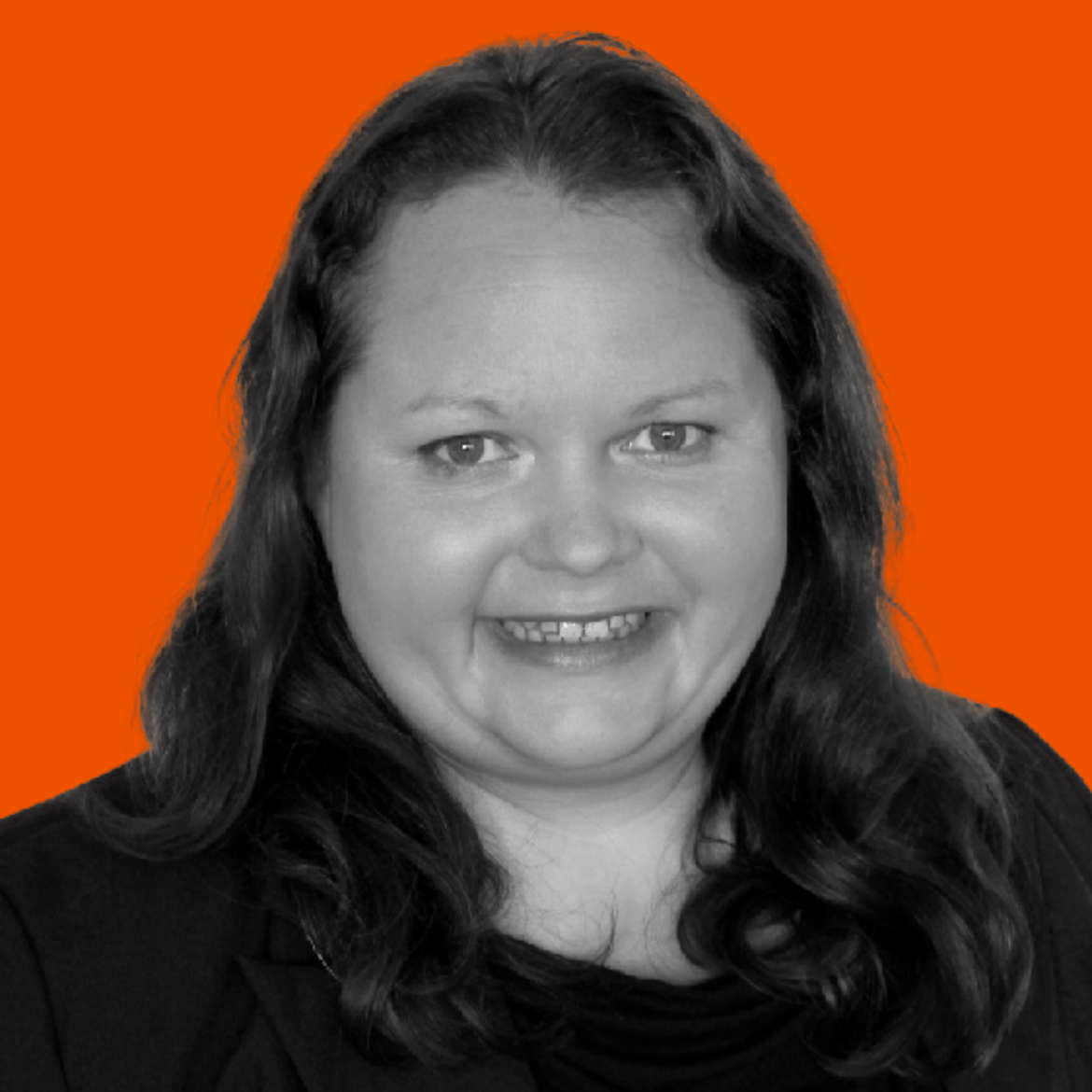 Black-and-white photo of a woman with long dark hair, smiling, against an orange background.