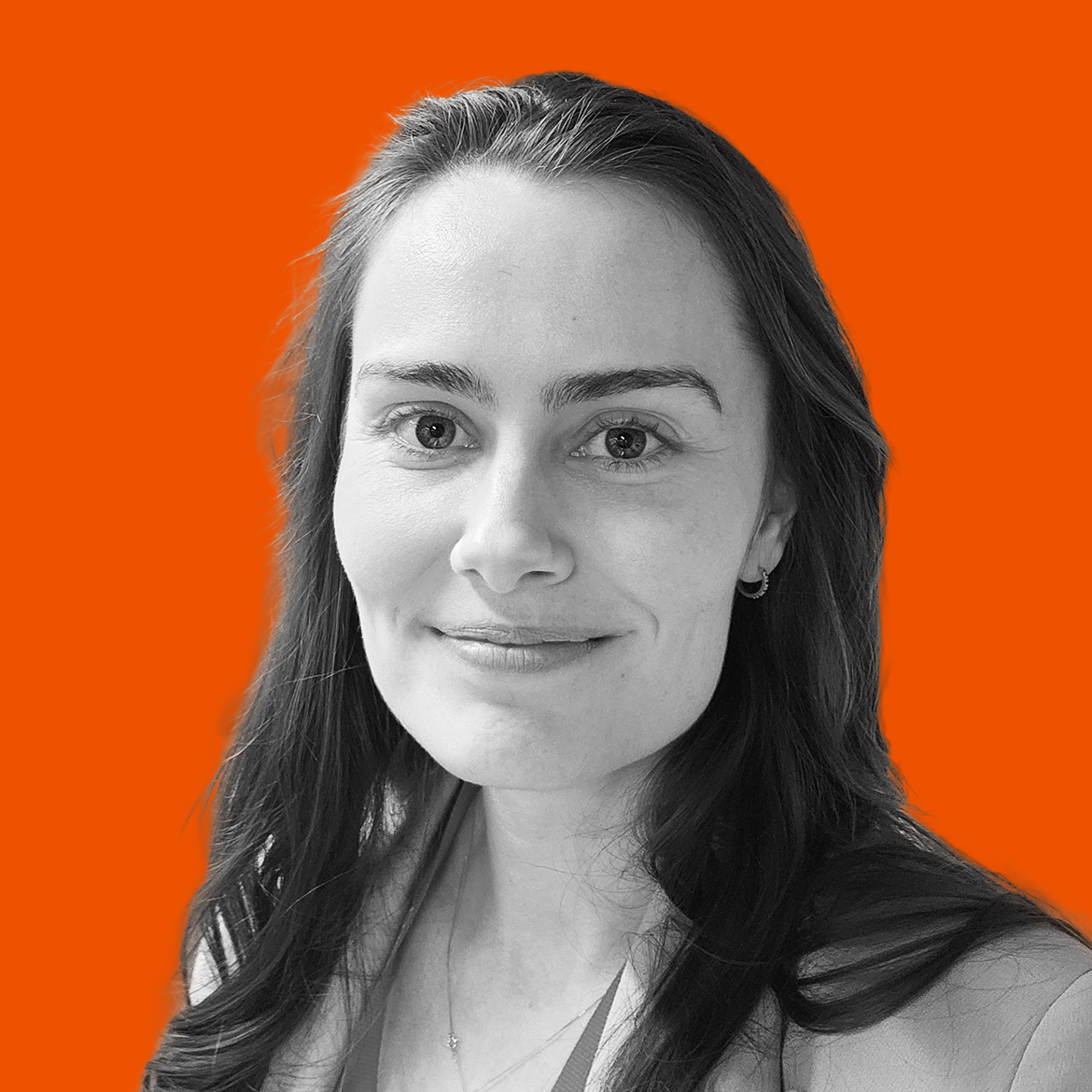 A black and white portrait of a woman with a slight smile, long wavy hair, and earrings, set against an orange background.