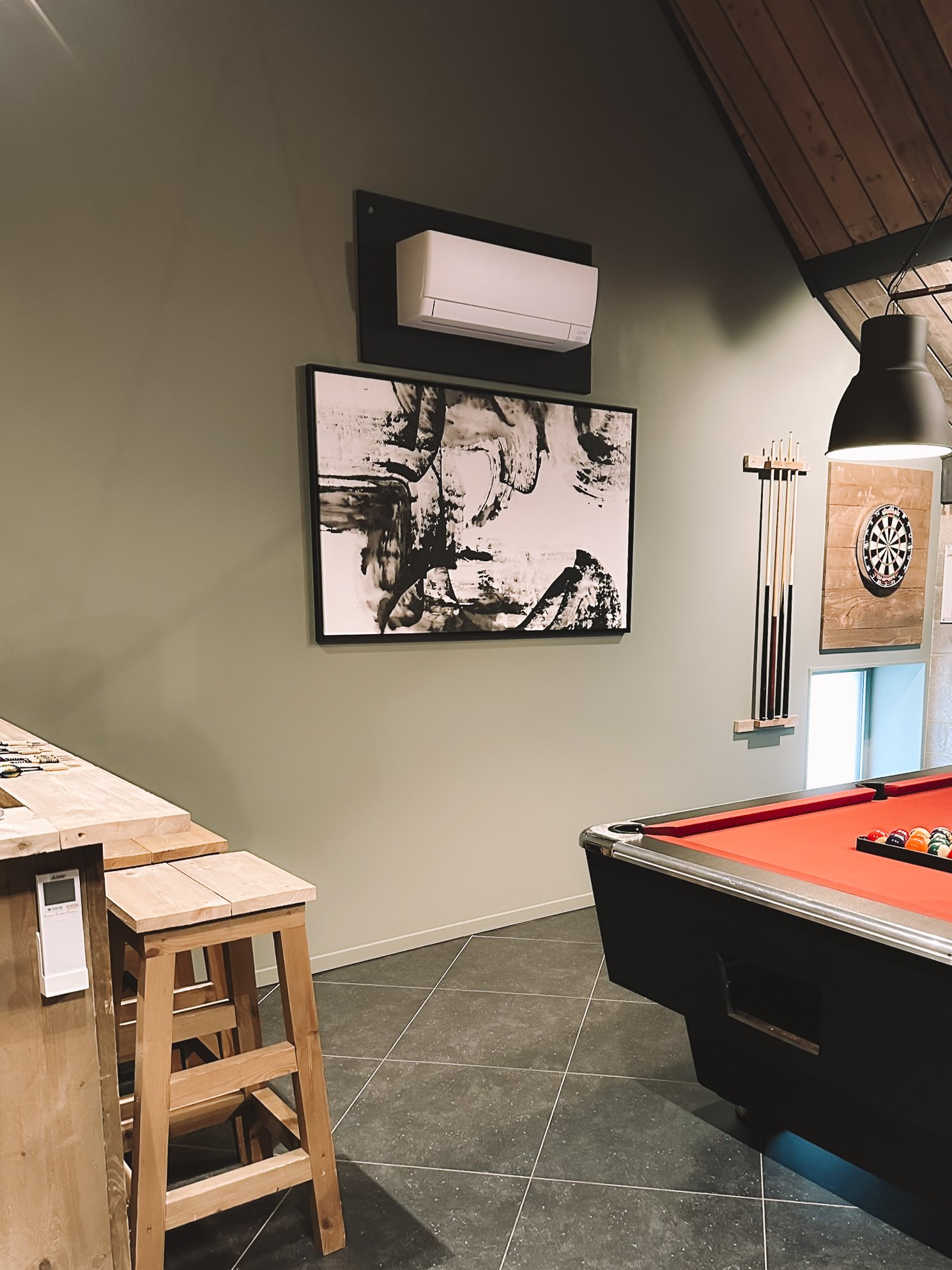 Mancave met een biljarttafel, bar en een dartbord.