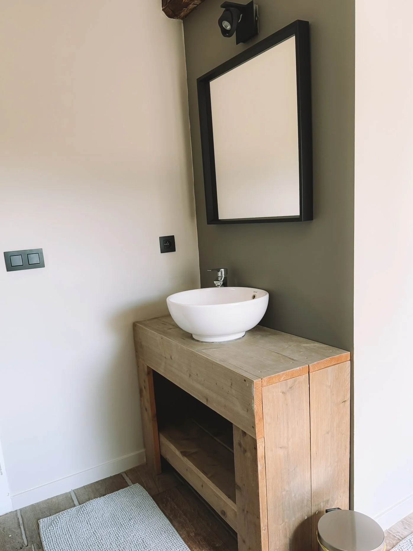 Een badkamer met een houten wastafel in vakantiehuis Au bord du Floyon.