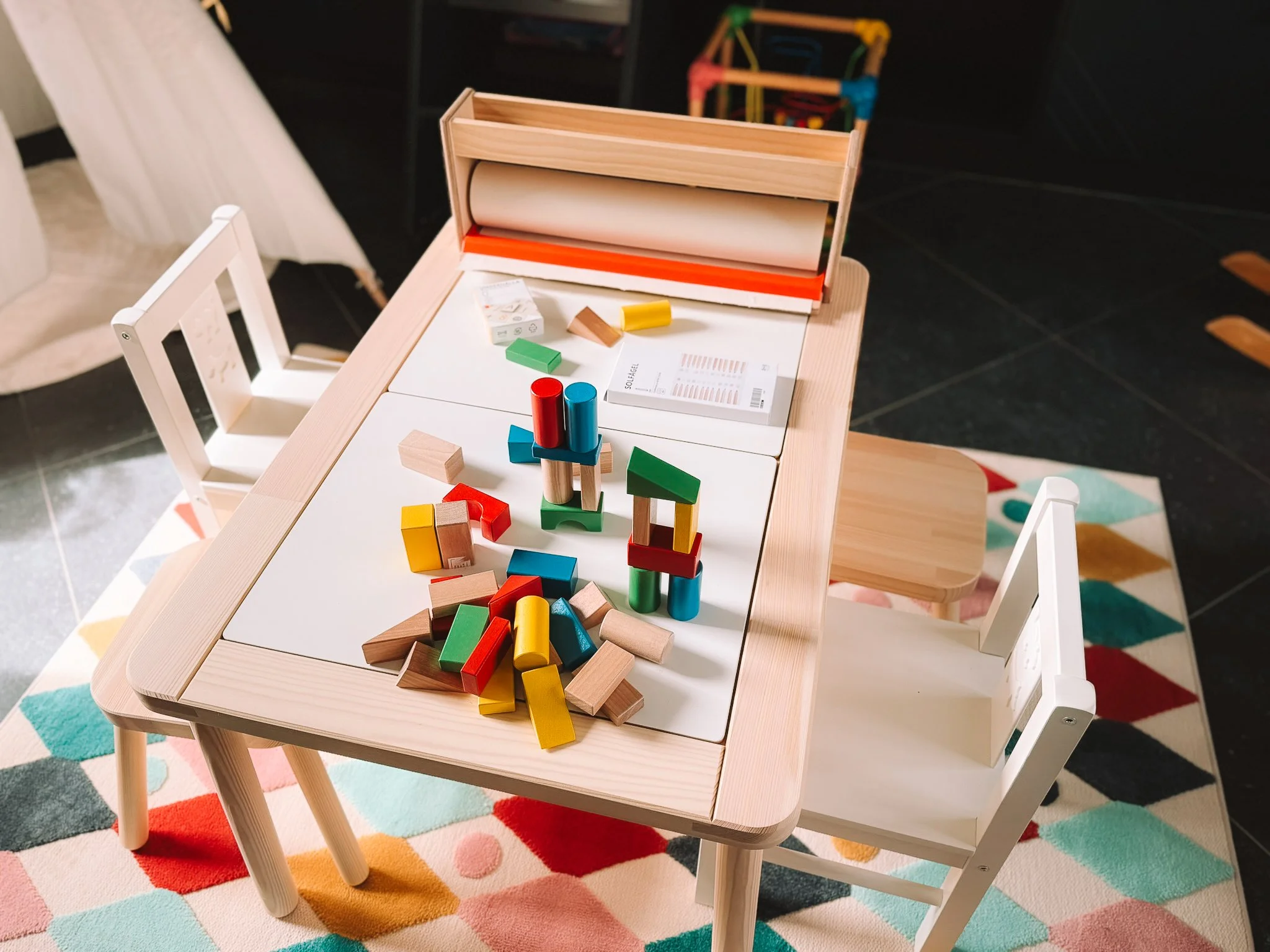 Gekleurd houten speelgoed op een kinderkeukentafel.
