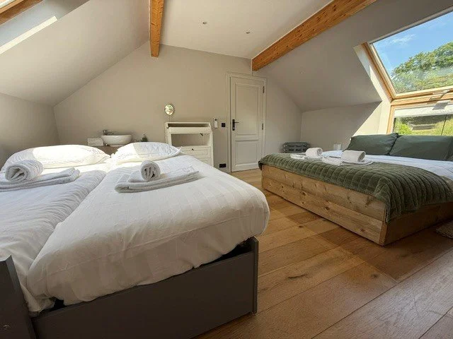 Een slaapkamer met een dubbelbed met beddengoed en kussens.