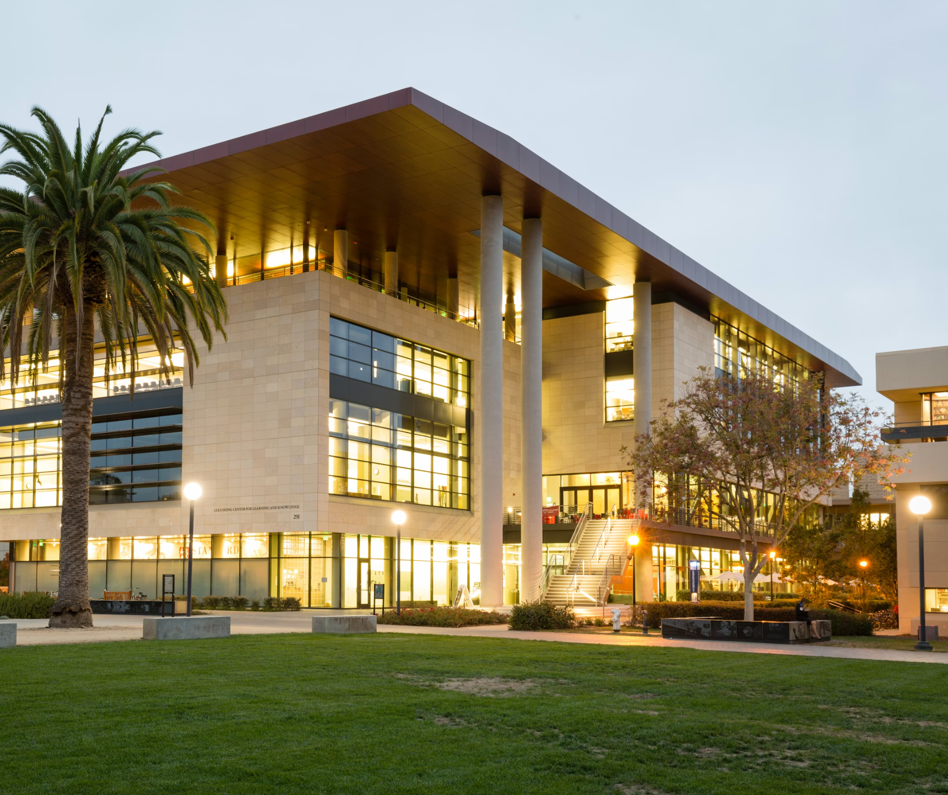A modern university campus building lit at dusk, representing higher education environments connected to college admissions consulting services.