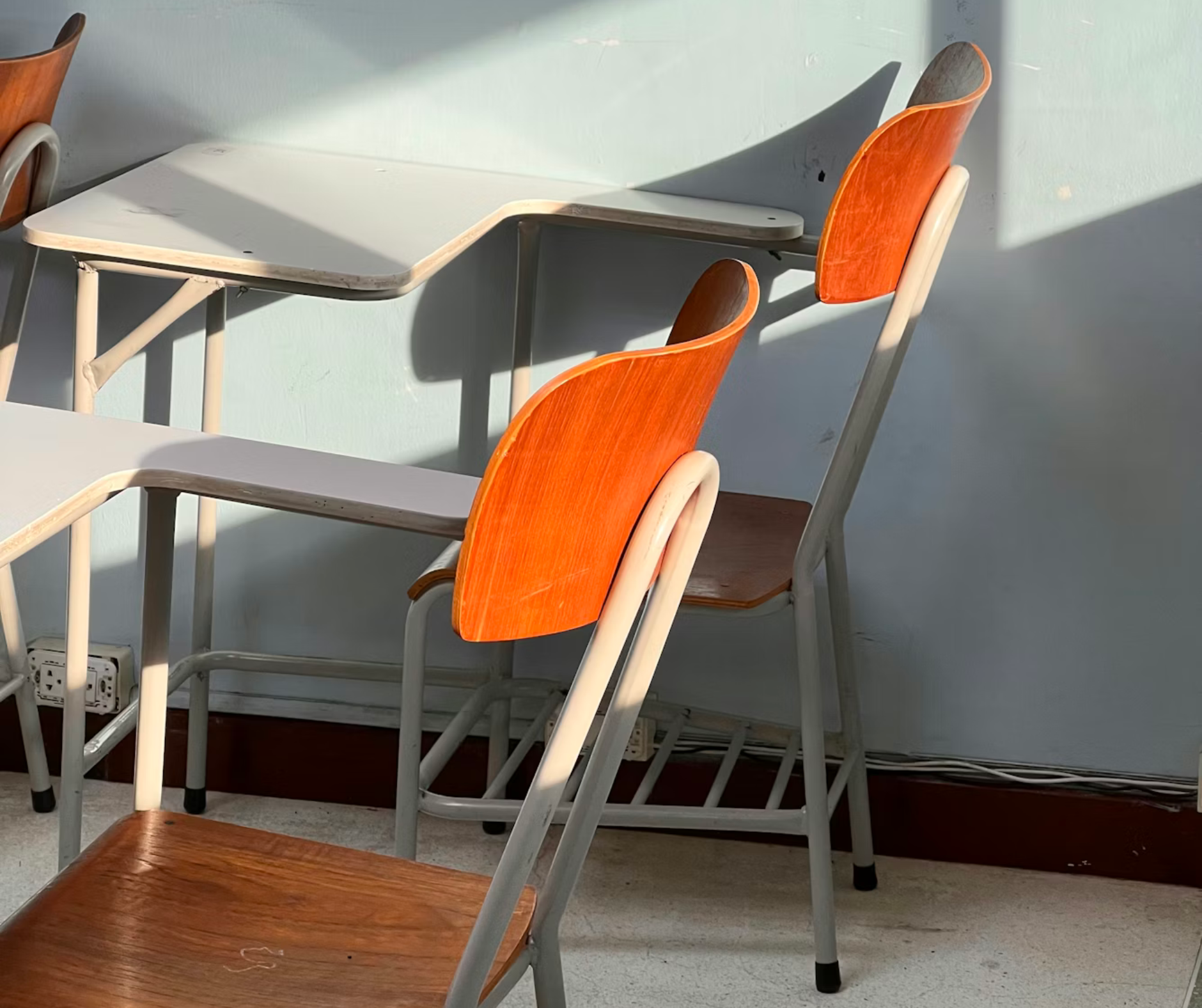 Sunlit classroom with empty desks and chairs, representing study spaces connected to college admissions counseling and academic planning.