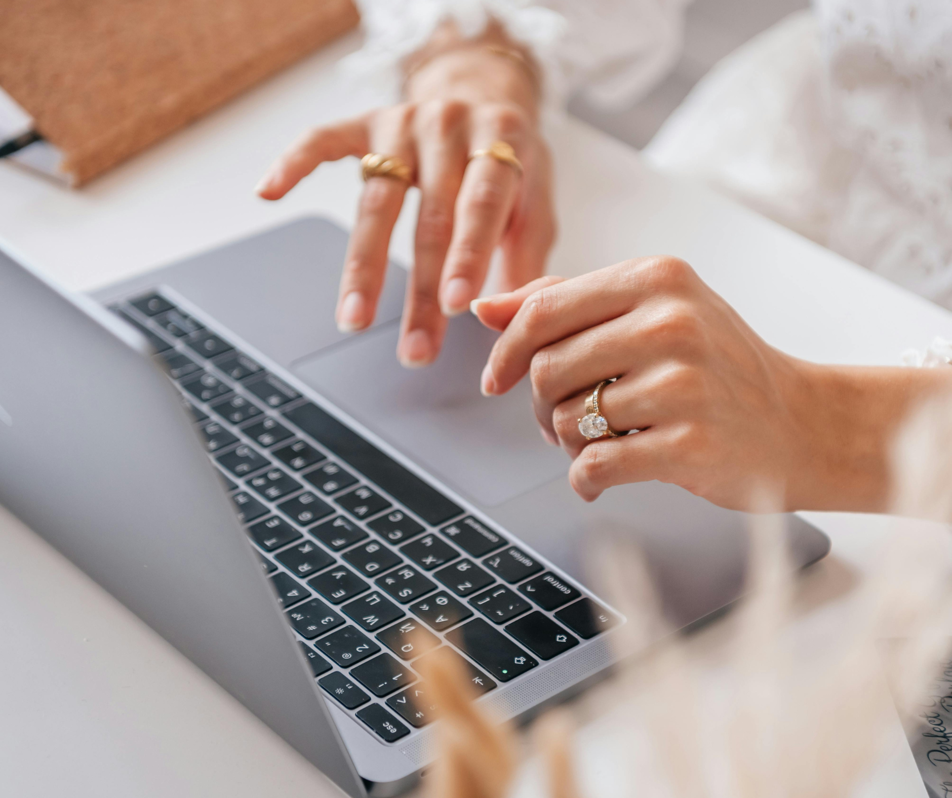 Close-up of hands typing on a laptop, working on college admissions counseling tasks and preparing application documents.
