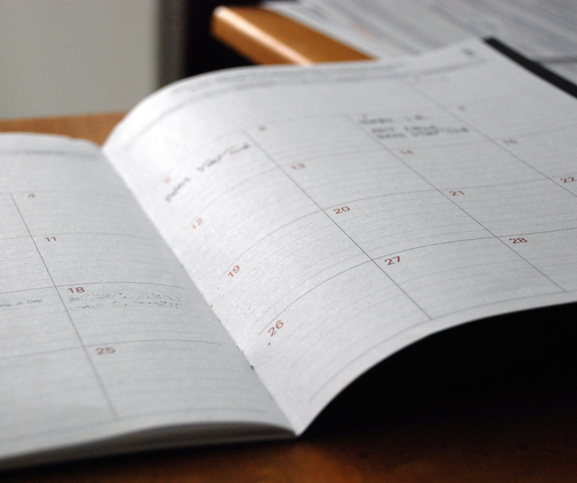 An open monthly planner showing important dates, highlighting the need for college admissions consulting and deadline management.