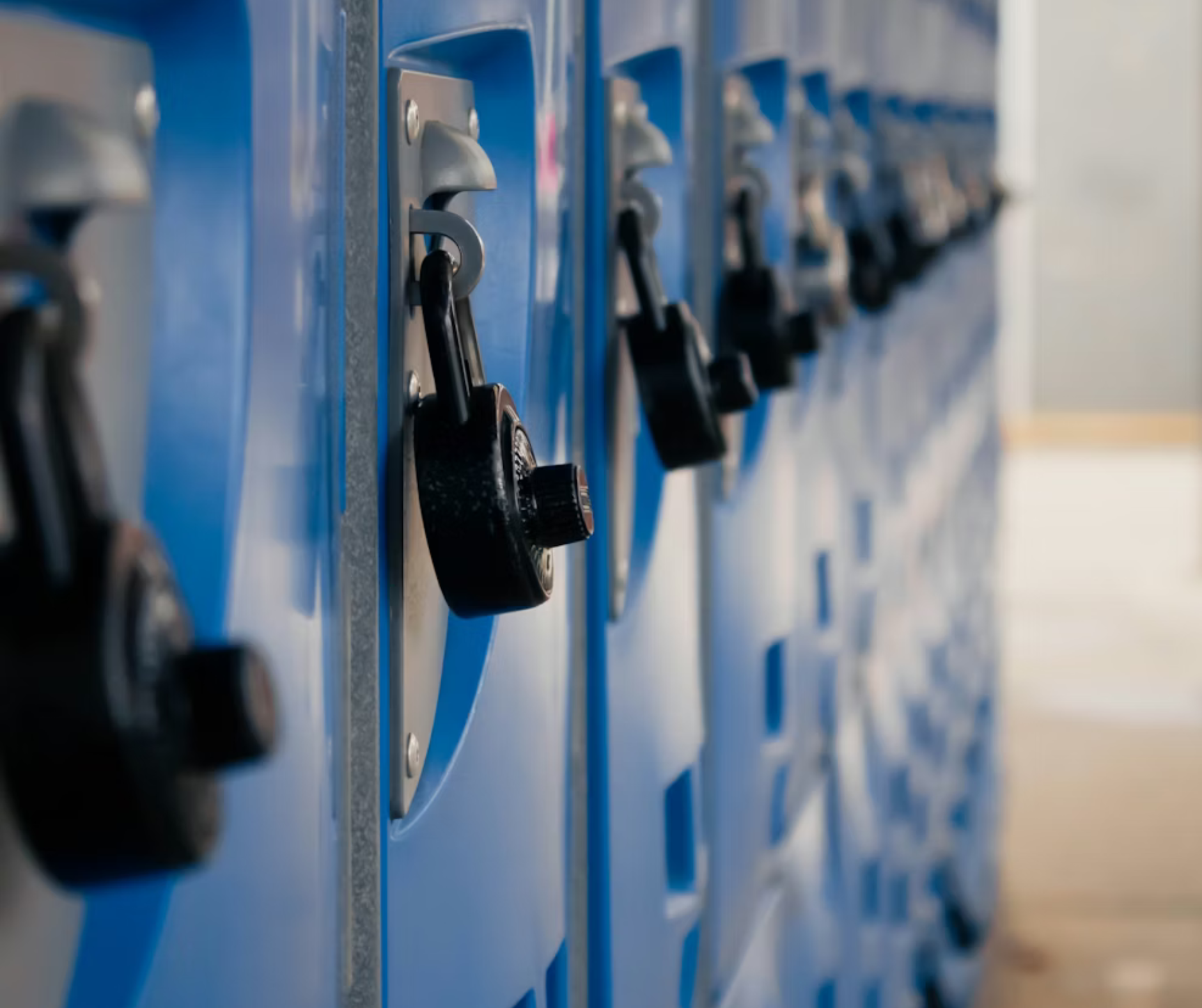 Blue school lockers with combination locks lining a hallway, representing student life and environments served by college admissions counseling.