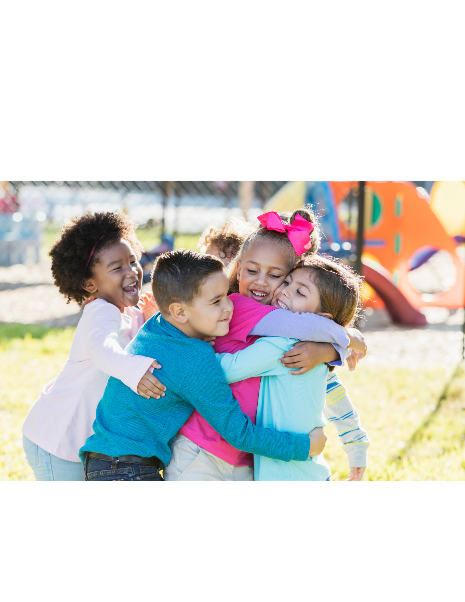 Group of smiling children hugging each other at playground