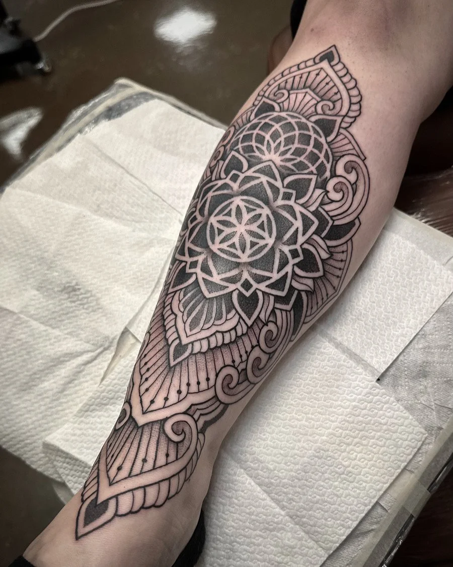 Tattoo käsivarressa, geometrinen ja kukkainen malli.