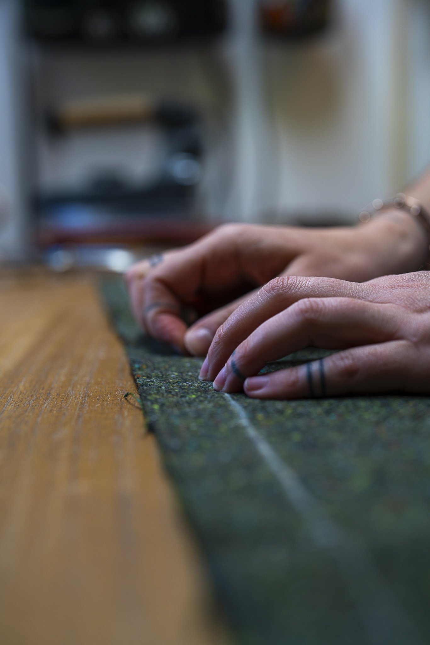 Close-up of hands working with fabric on a table.