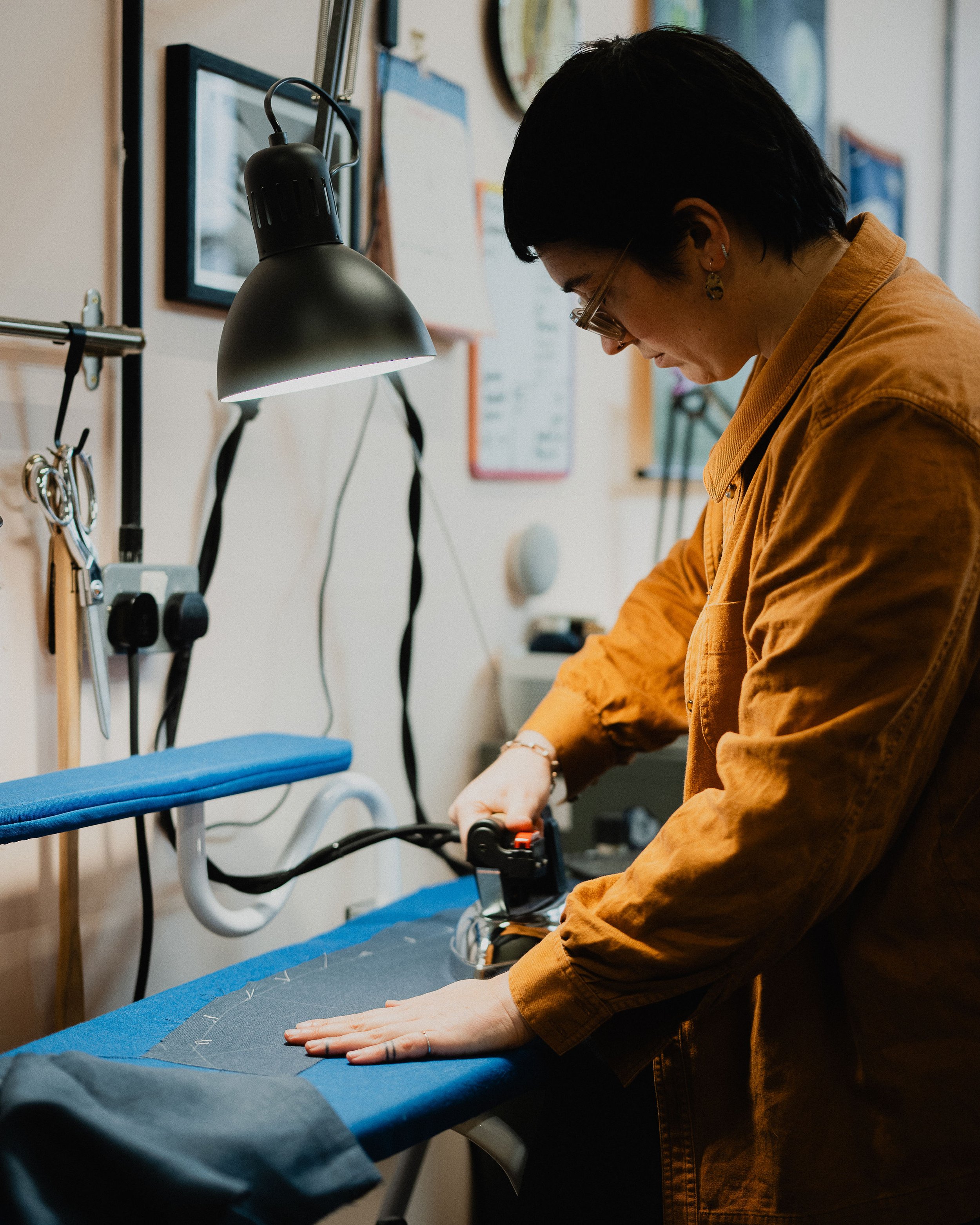 A person ironing a piece of fabric on an ironing board in a well-lit room.