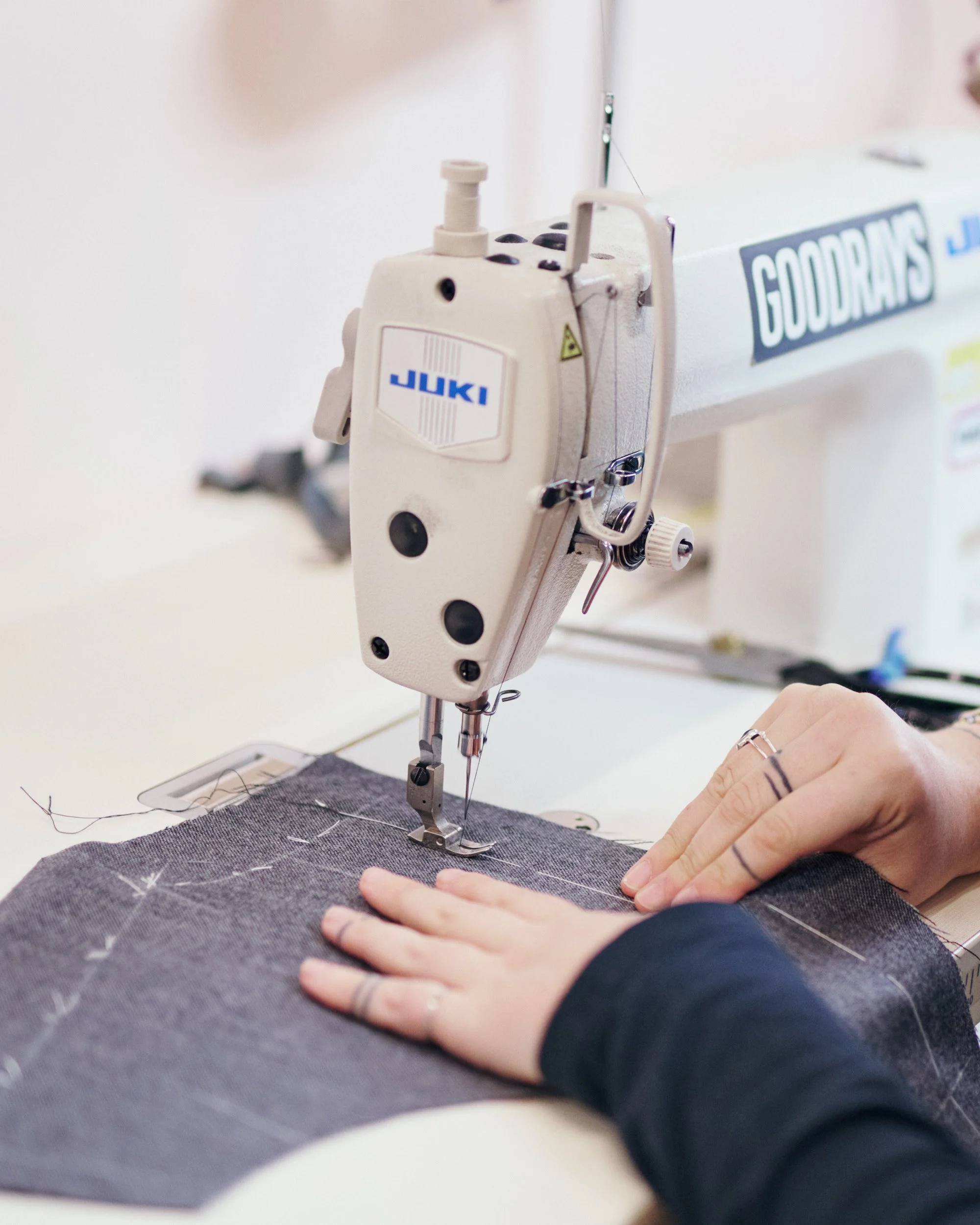 Shot from behind a woman with short hair is measuring a man with a tape measure