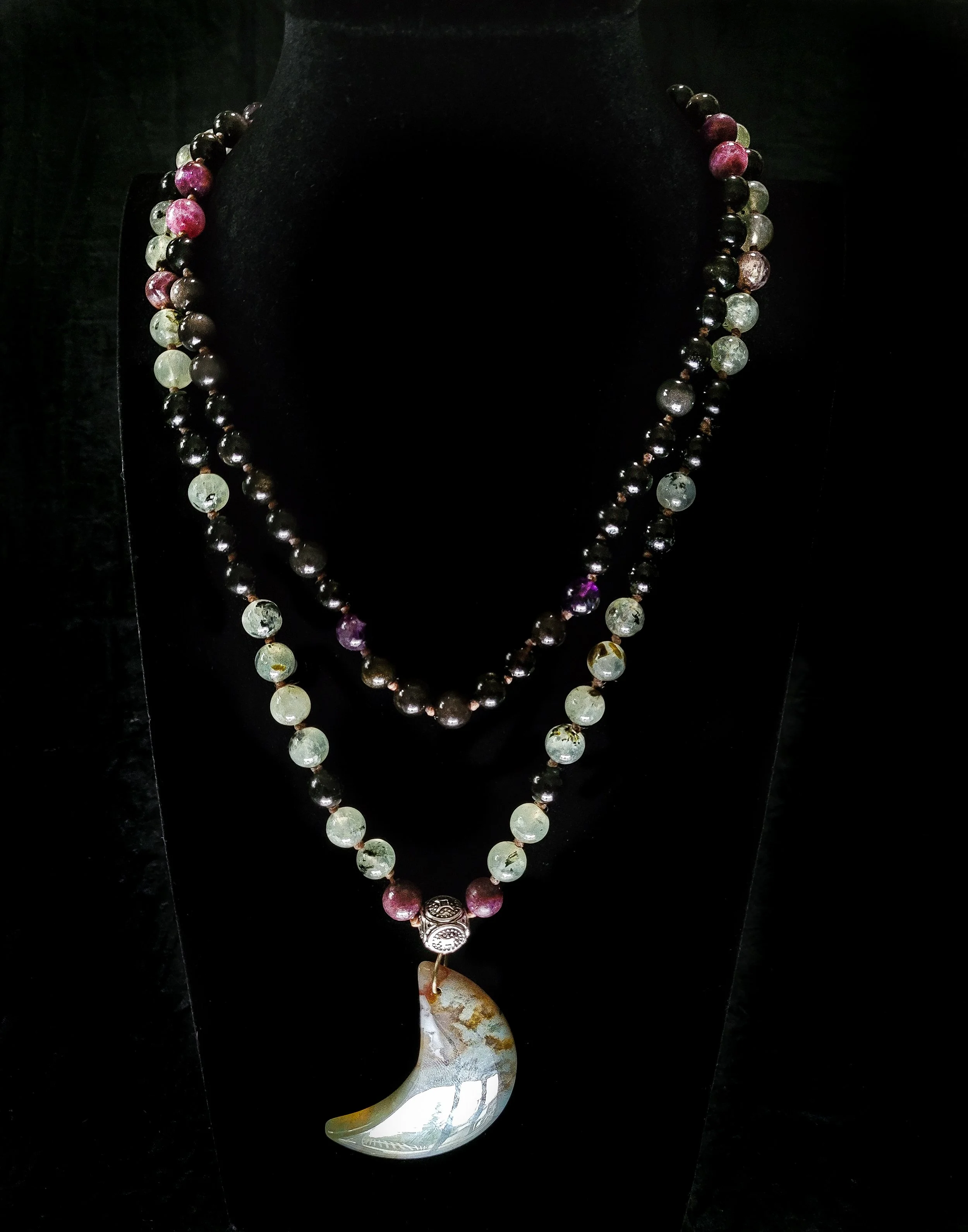 Photo custom-made limited gemstone mala necklace with 6mm super seven amethyst, prehnite, rainbow and black tourmaline, and silver sheen obsidian round gemstones; 4mm ornate round silver bead; and large light green and brown moss agate crescent-moon 