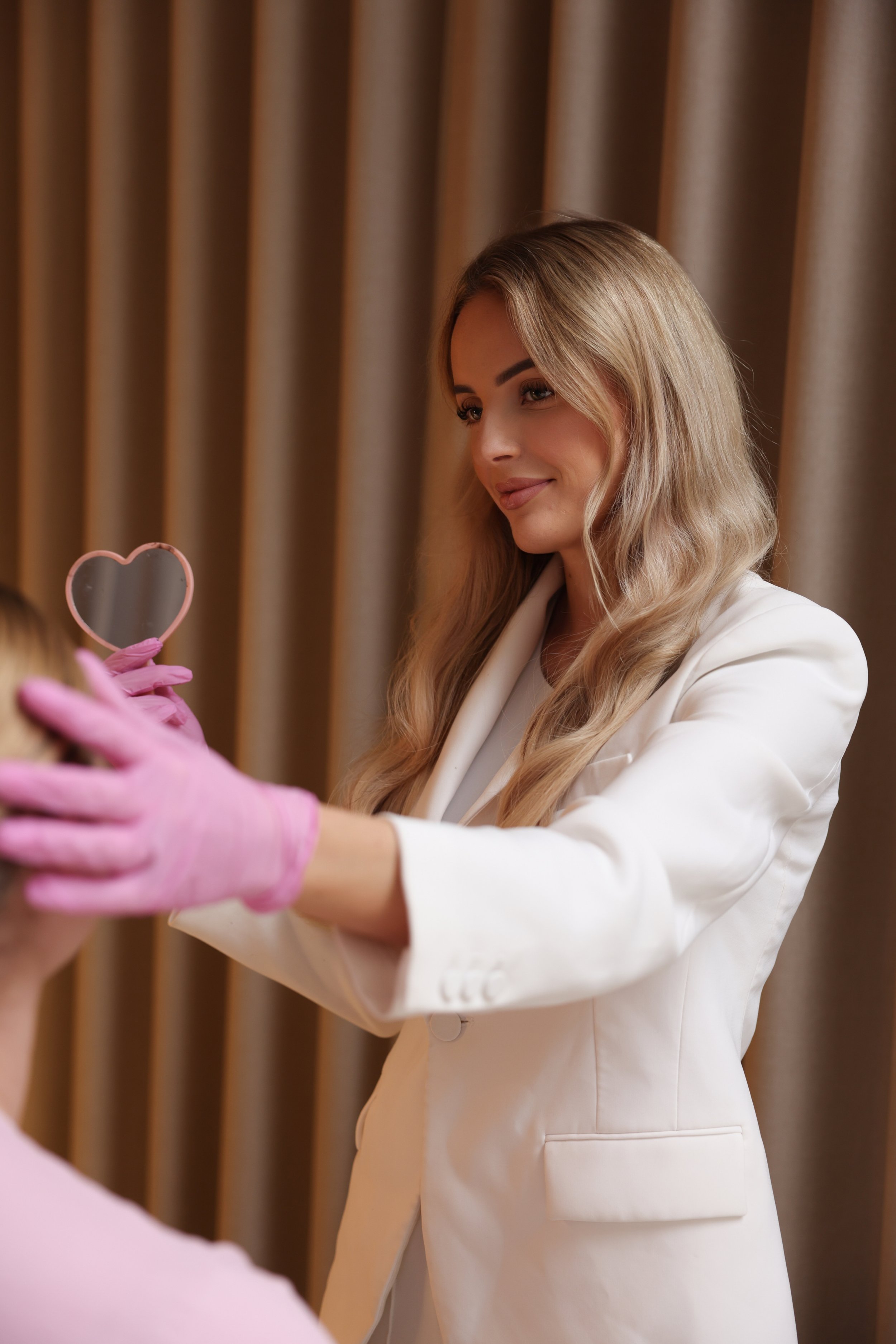 eigenaresse schoonheidssalon Beauthé die de klant het resulaat laat zien van de behandeling