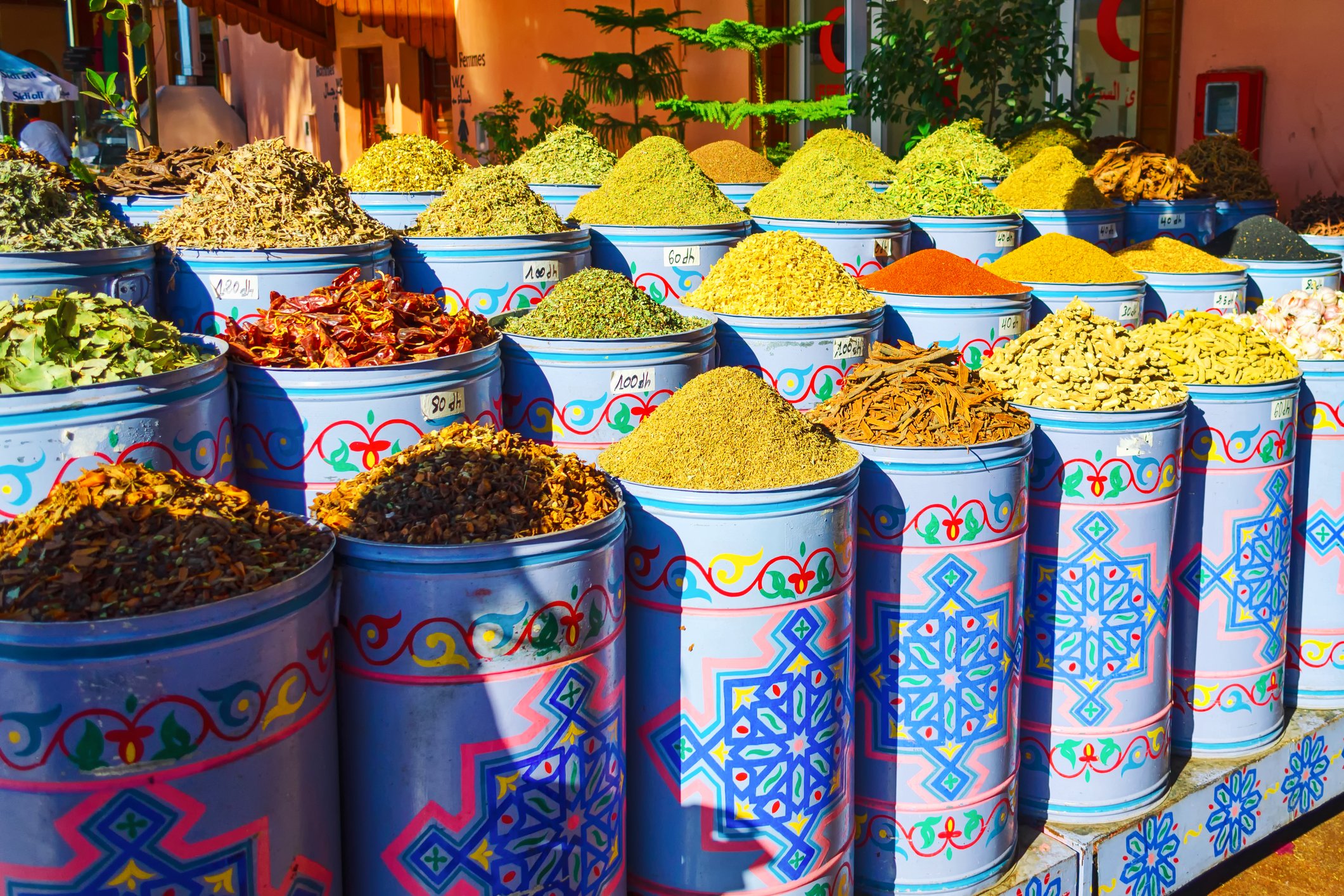 Colorful outdoor spice market with large containers filled with various spices and herbs
