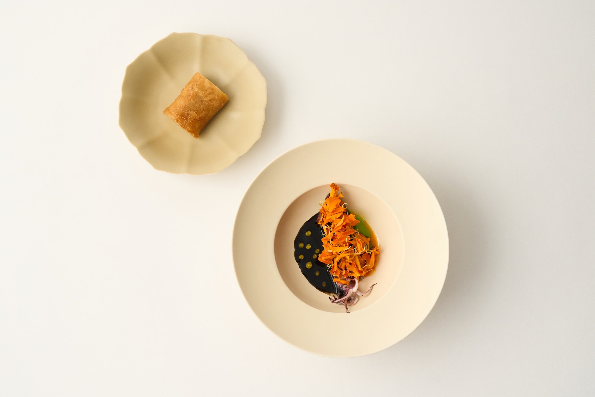 A signature dish from The Rochers — charcoaled local calamari with a velvety ink sauce, fragrant garden flowers, and golden potato crêpe. Rooted in Ojai, inspired by the seasons.