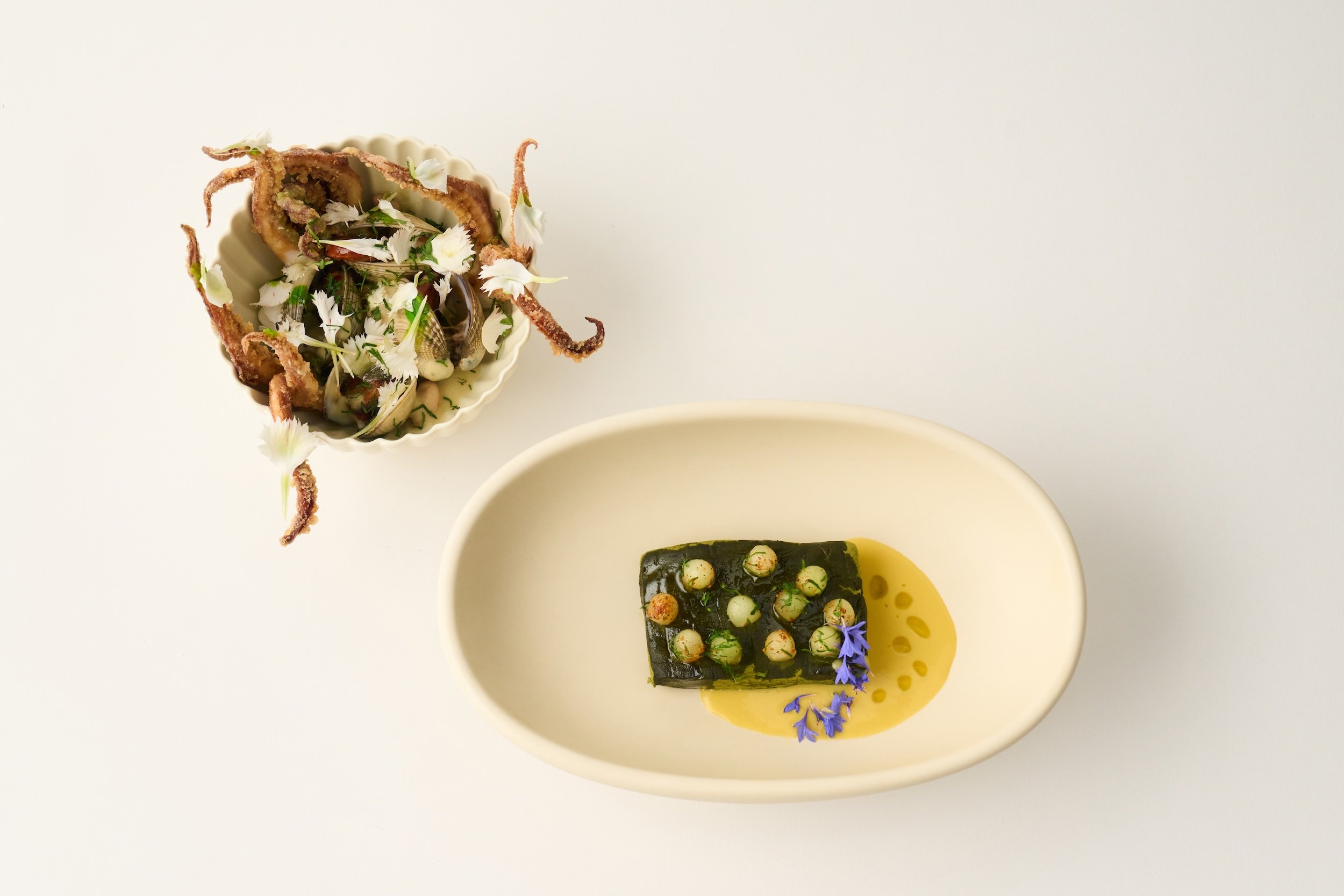 Halibut dusted in matcha sits atop a silky corn purée — sweet, rich, and golden. On the side: clams in an herb-laced broth, topped with crispy tentacles. Fresh, vibrant, and full of ocean energy, this duo captures the brightness of the season, with g