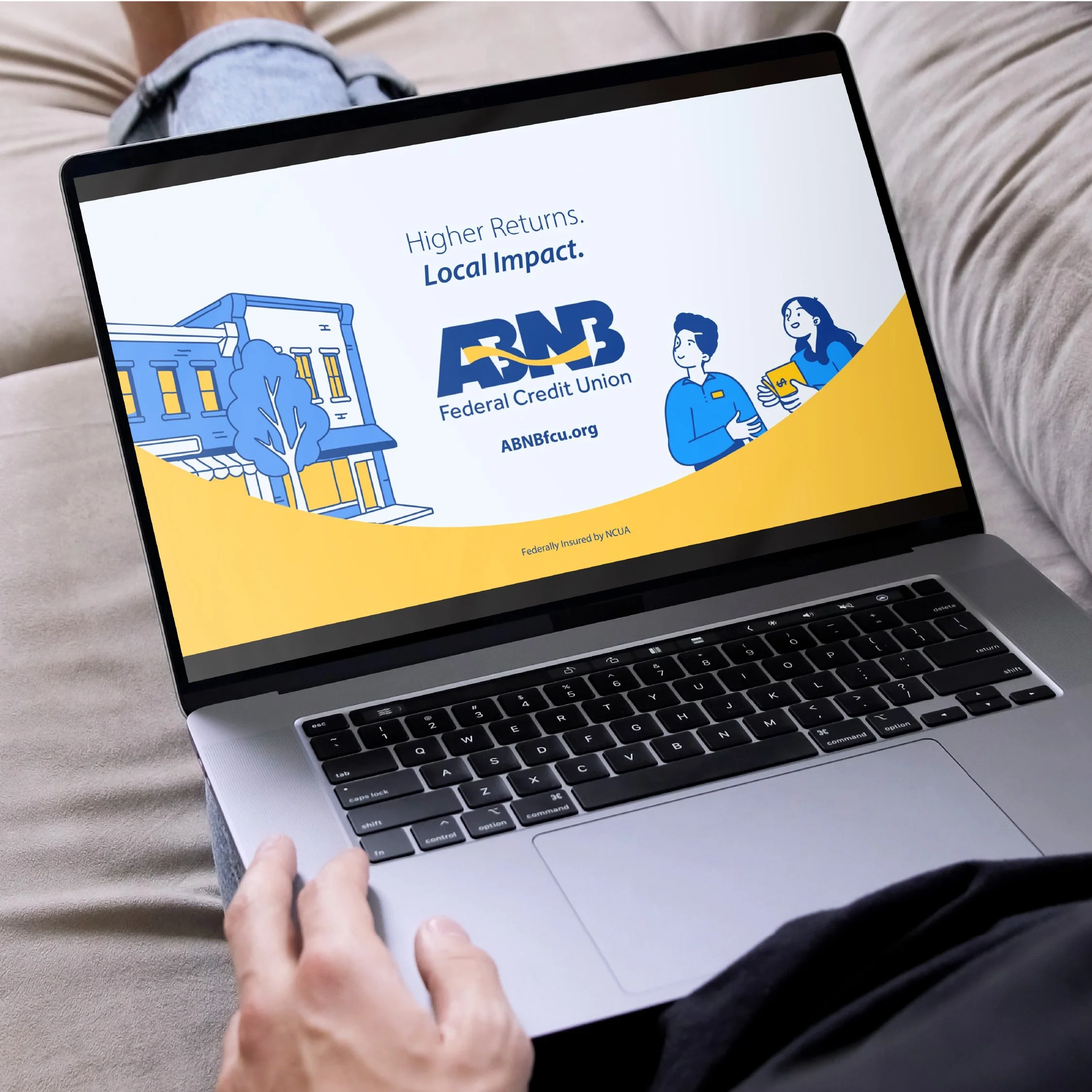 Laptop screen displaying an advertisement for ABNB Federal Credit Union with the logo, website, and illustrations of a building and two people.