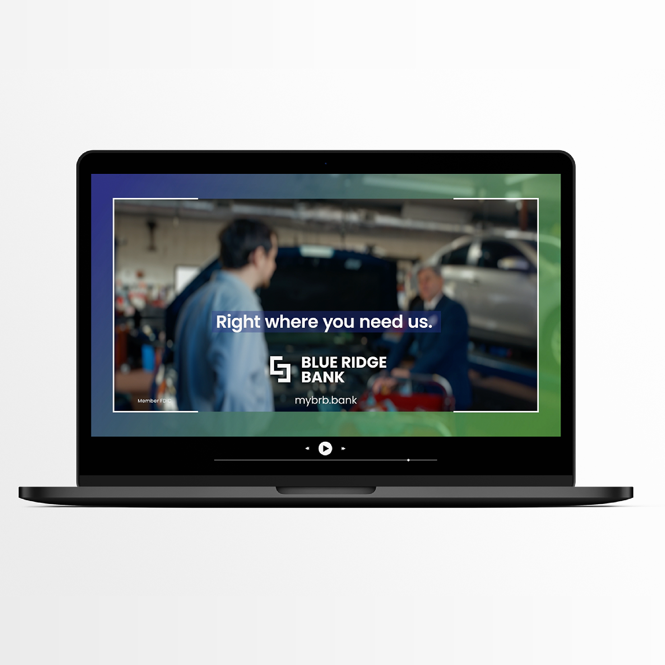 Laptop screen displaying an advertisement for Blue Ridge Bank, with a blurred background showing two men in suits at an auto repair shop. The text says "Right where you need us" and includes the bank's logo and website, myrbb.bank.