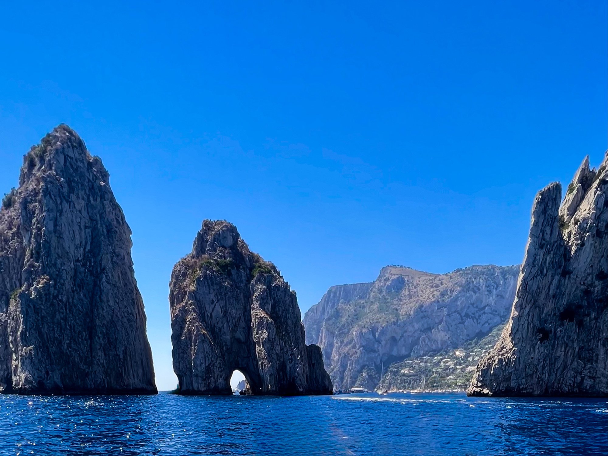 Sea stacks and cliffs along a blue ocean with clear skies