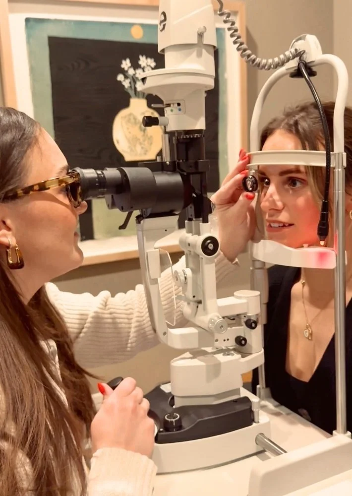 An eye doctor performing an eye examination using a slit lamp with a patient.