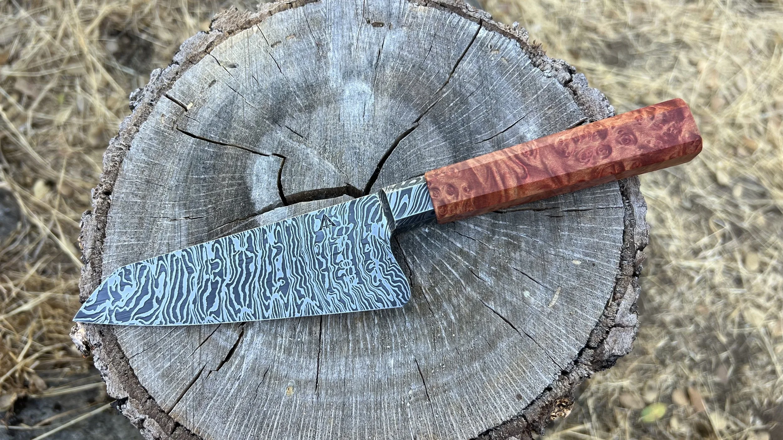 Twisted damascus kitchen knife with integral bolster