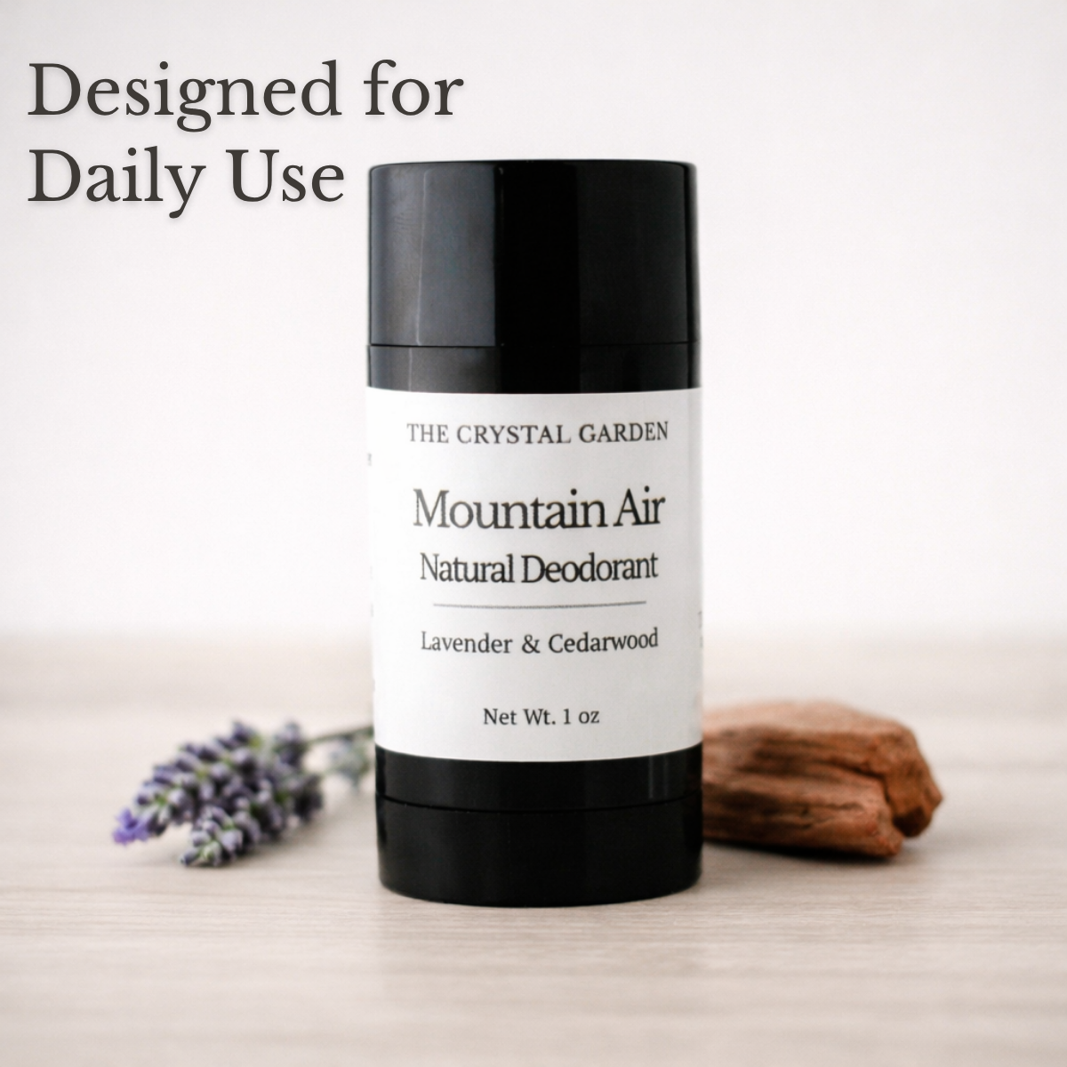 Round black deodorant tube labeld Mountain Air with lavender and cedarwood by The Crystal Garden surrounded by botanicals on nutural background.