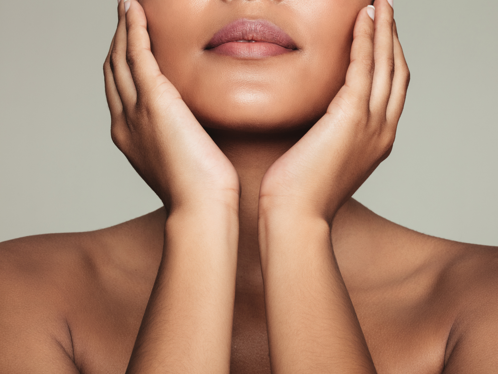 view of women hold her face, blissful look on her face with radiant skin