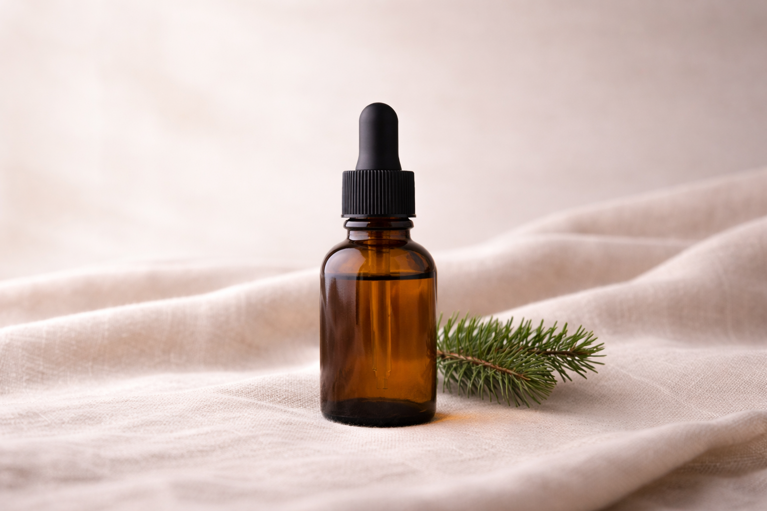 Amber glass bottle on linen fabric with fir spriAmber glass bottle on linen fabric with fir sprig in a natural, botanical settingg in a natural, botanical setting