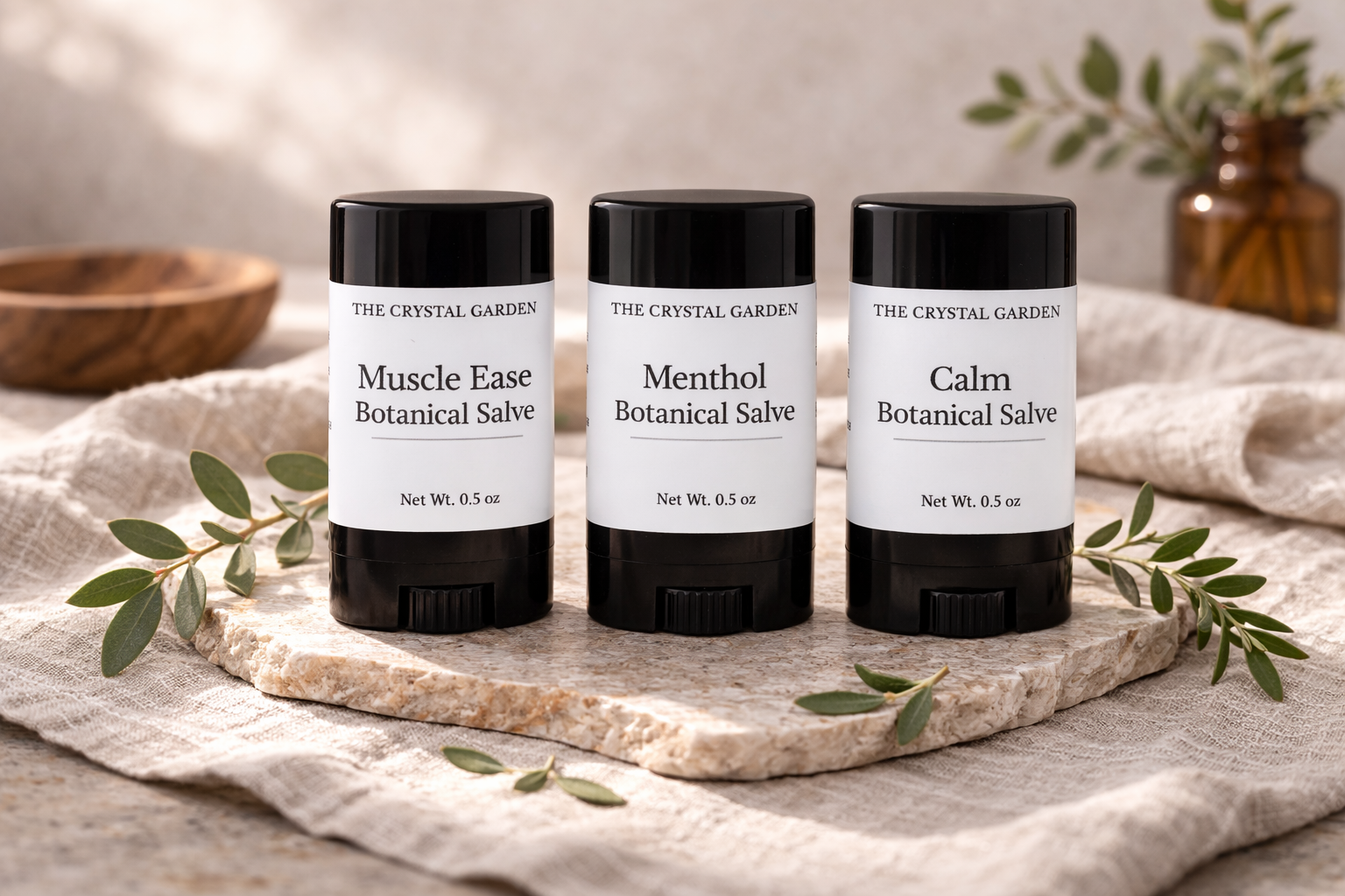 Three botanical salve tubes in a natural linen setting for plant-based topical care