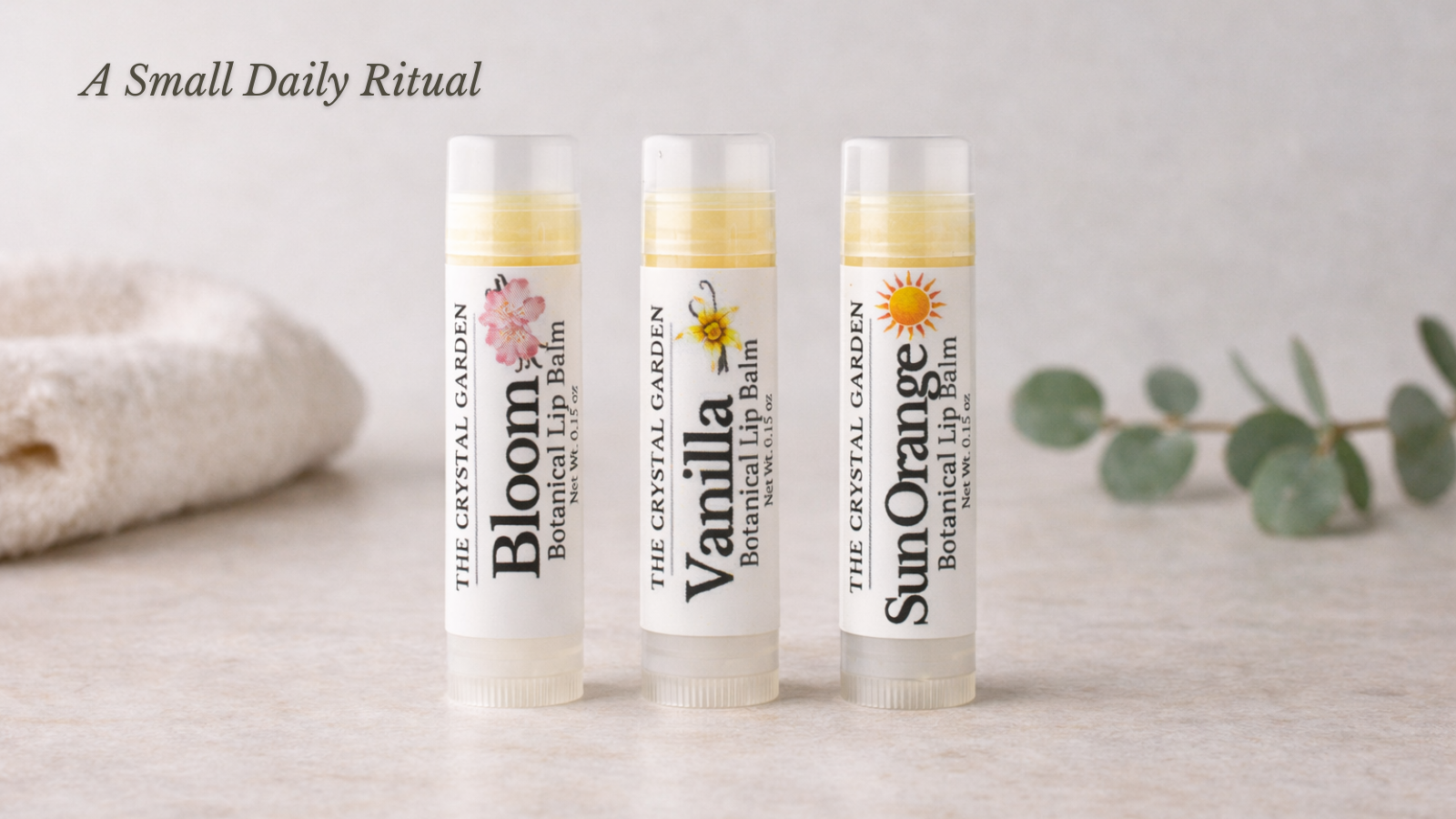 Botanical lip balm collection displayed on a countertop including Vanilla, Bloom, and Sun Orange plant-based lip balms.