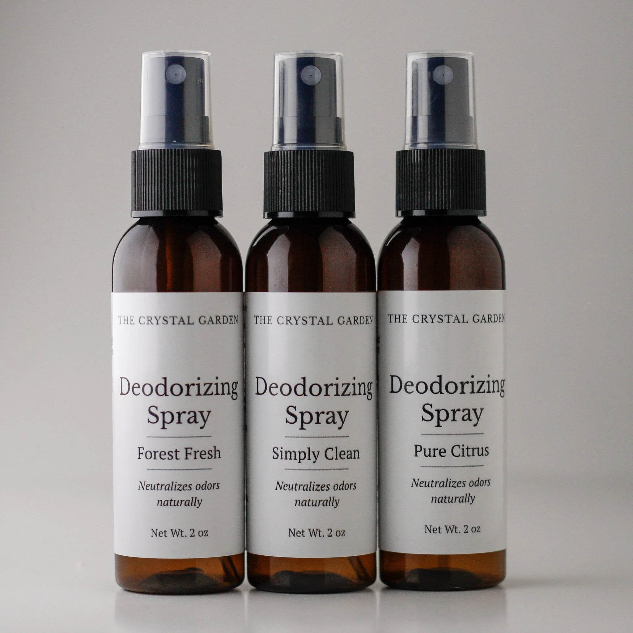 Three amber spray bottles labeled with different deodorizing sprays, including 'BINDOONE', 'SNIF OFF', and 'TRASH TALK', each with a black spray nozzle and white labels.