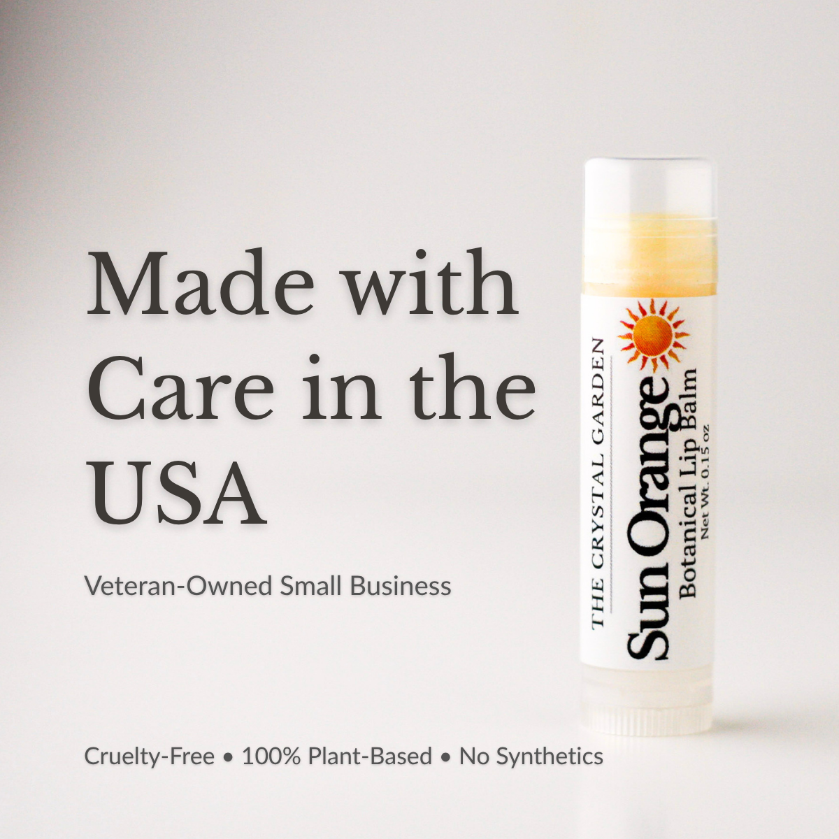 Sun Orange lip balm in white tube with botanical label on a white to light gray background., supporting photo.png
