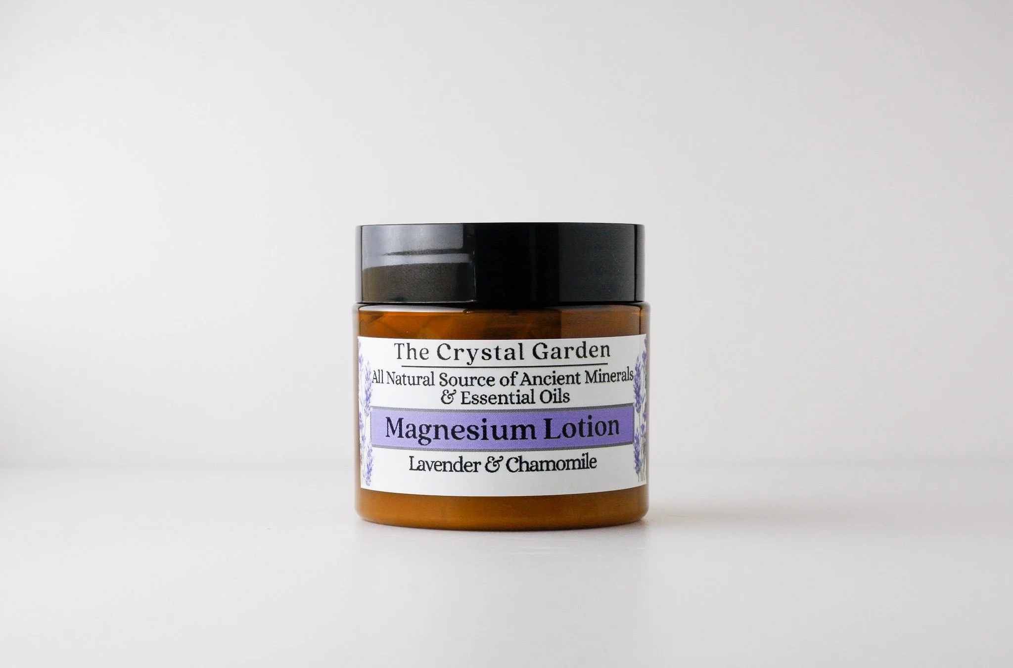 Brown jar of magnesium lotion with lavender and chamomile on white background