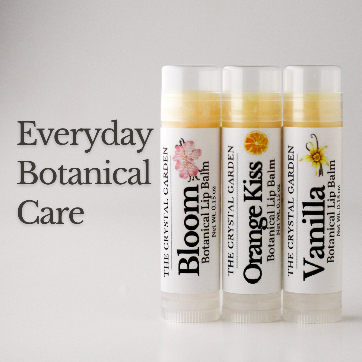 Vanilla Trio lip balm set with Vanilla, Orange Kiss, and Bloom lip balms on a stone surface with soft neutral background.