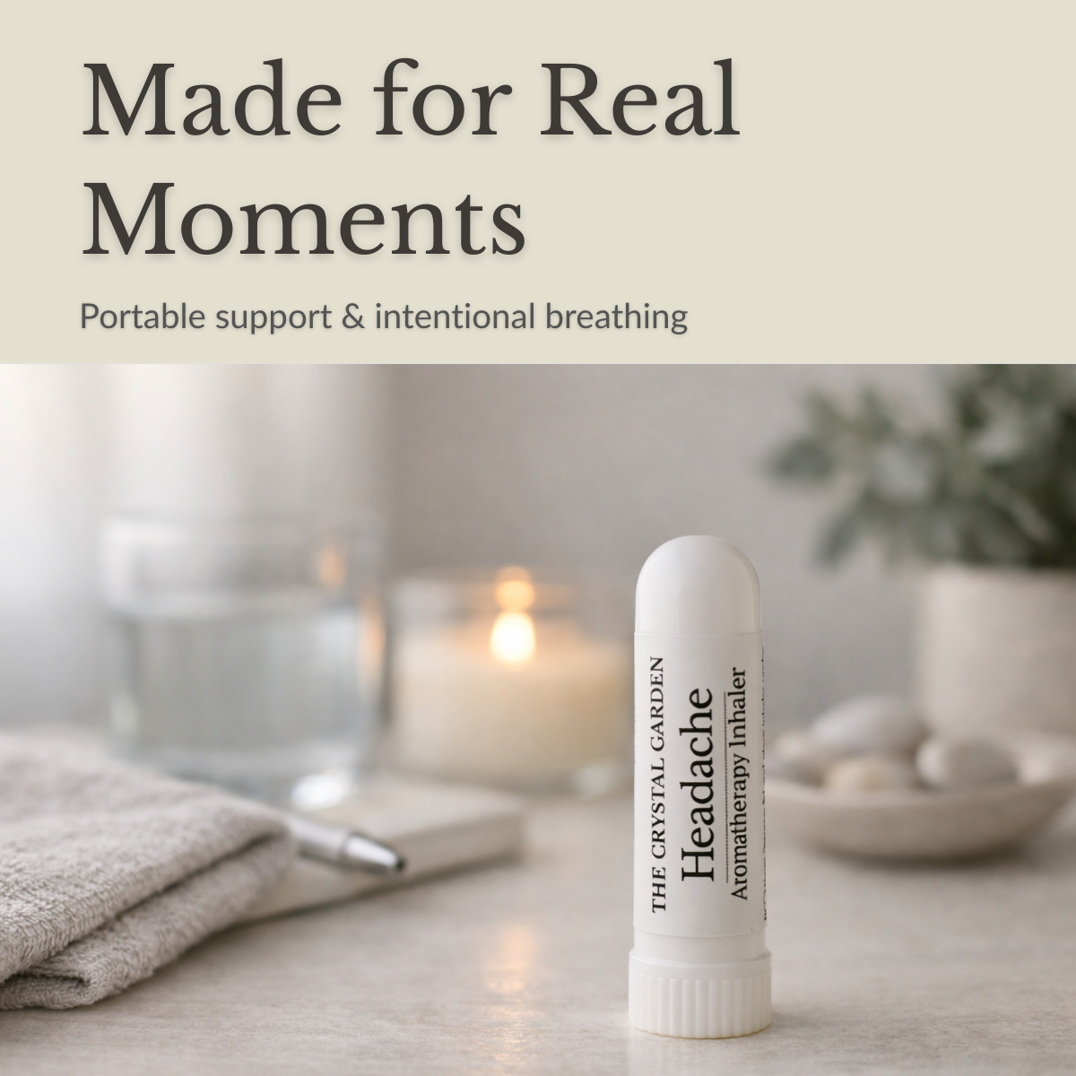 Headache aromatherapy inhaler standing on a neutral surface with a folded towel, glass of water, and candle in a calm minimal setting.