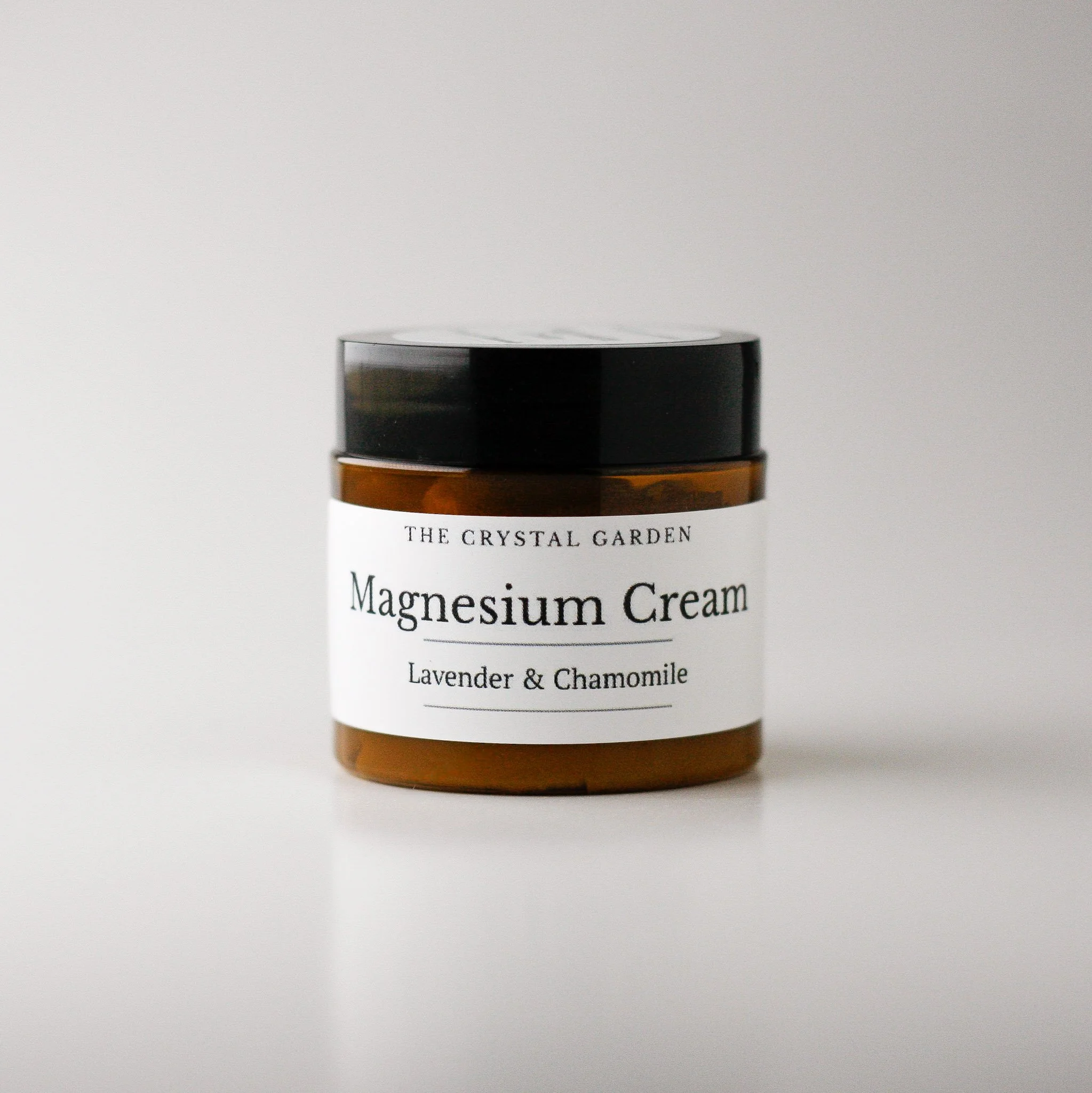 Brown jar of magnesium lotion with lavender and chamomile on white background