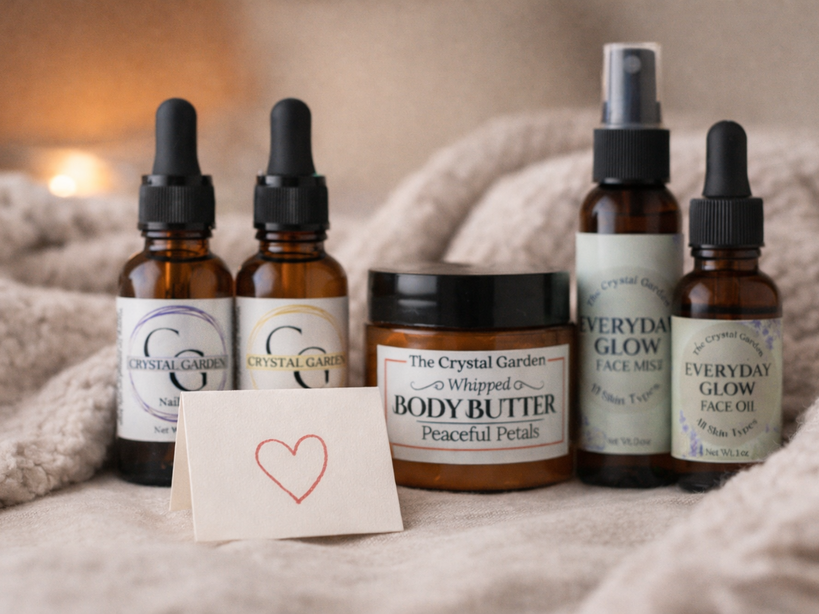 close up of products by the crystal garden with soft cream colored blankets as a back drop. Folded card with heart