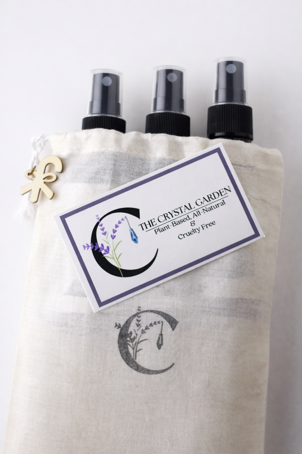 5x7 muslin bag stamped with the crystal garden logo holding 3 2oz spray bottles