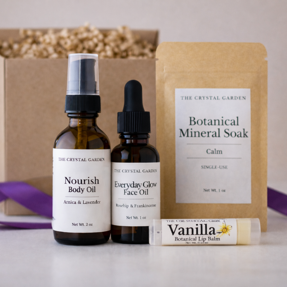 Plant-based self care gift set with body oil, face oil, botanical mineral soak, and lip balm on a neutral background