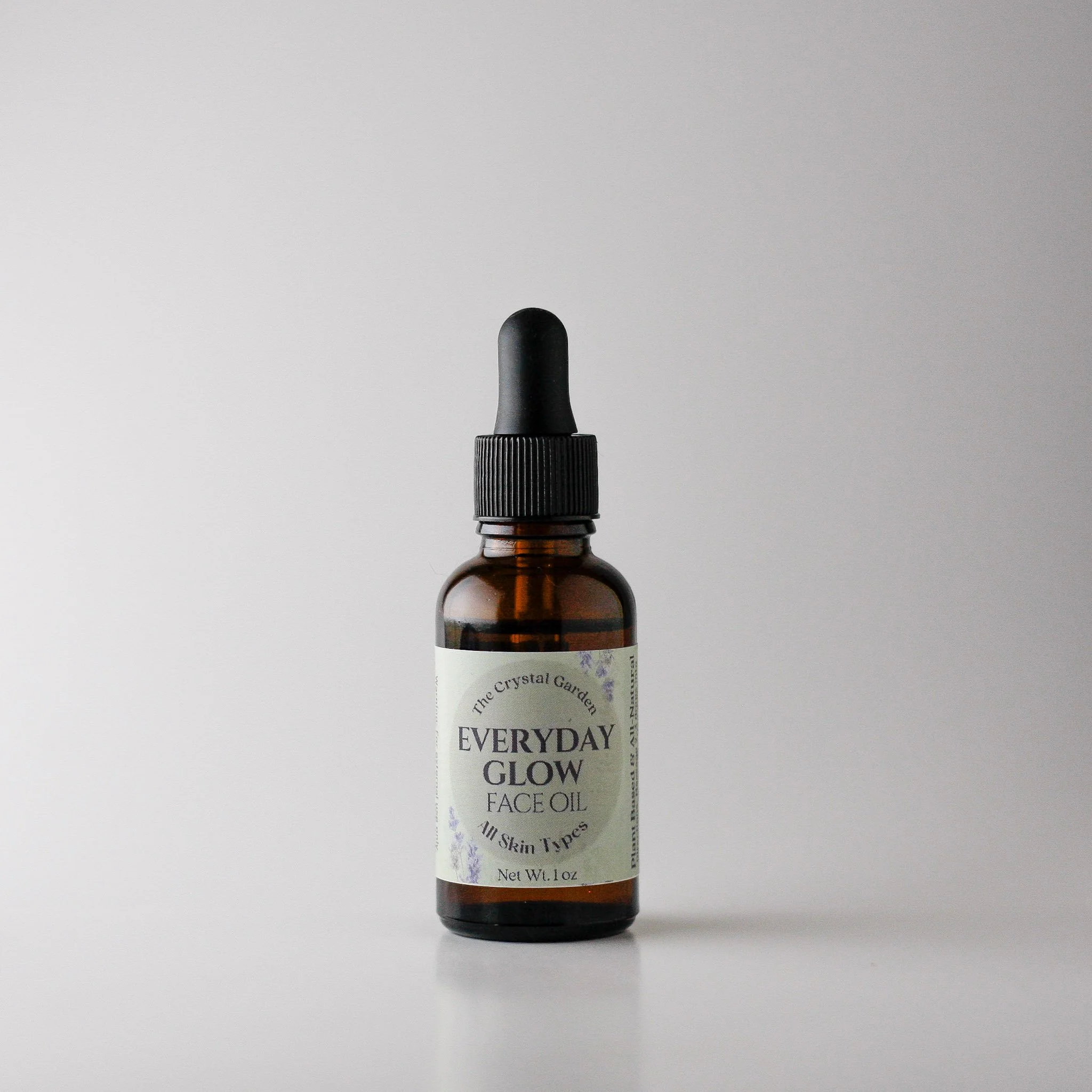 amber dropper bottle labeld everyday glow face oil on nutural back ground