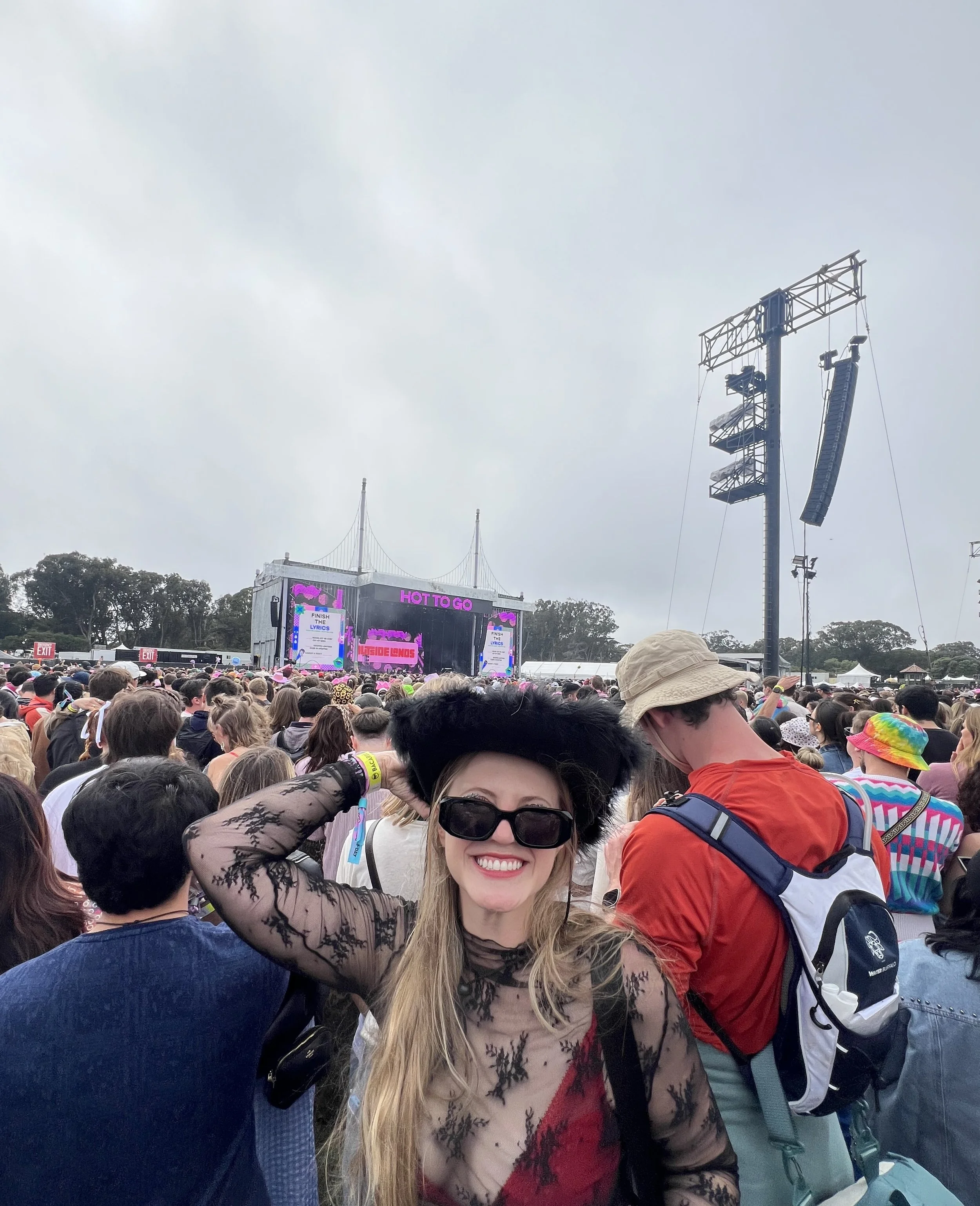 A silhouette of a person performing as a DJ on stage, illuminated by blue spotlight and surrounded by dark ambient lighting and fog.